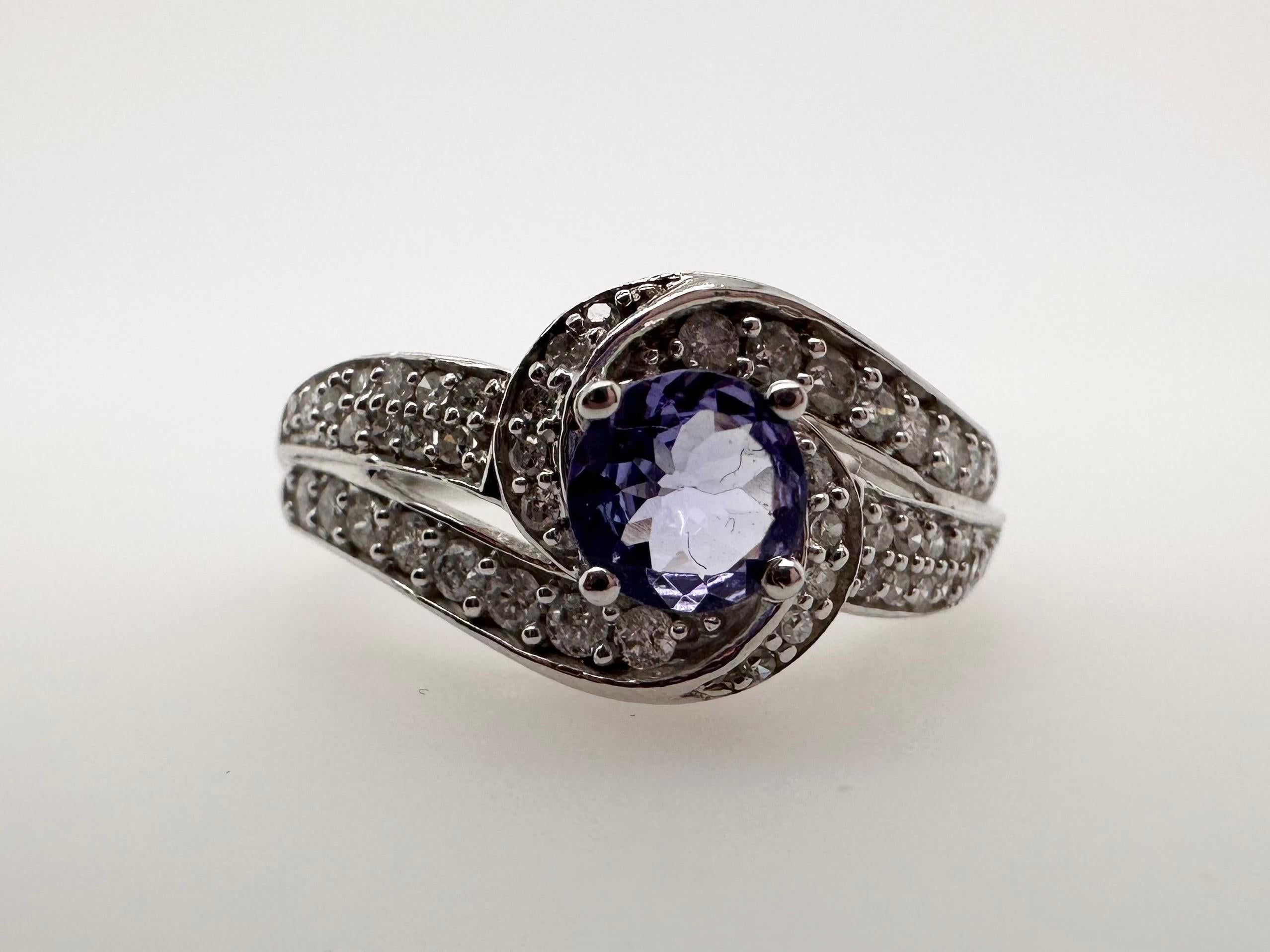 Tanzanite diamond ring infinity style ring in 10KT gold.

Metal Type: 10KT

Natural Tanzanite(s):
Color: Violet
Cut:Round
Carat: 0.60ct
Clarity: Slightly Included

Natural Diamond(s): 
Color: G-H
Cut:Round Brilliant
Carat: 0.65ct
Clarity: SI