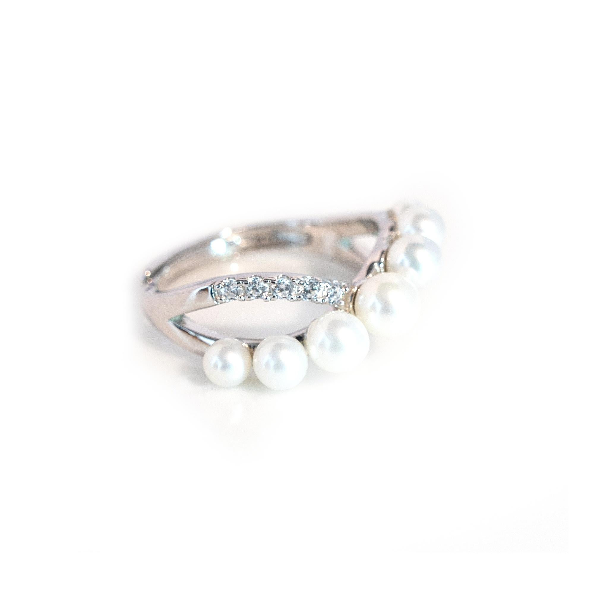 Cette exquise bague de créateur est une véritable incarnation de l'élégance. Fabriquée avec précision et passion, cette bague en argent sterling est ornée de perles d'eau douce et d'éblouissants diamants en zircon cubique, créant ainsi une pièce