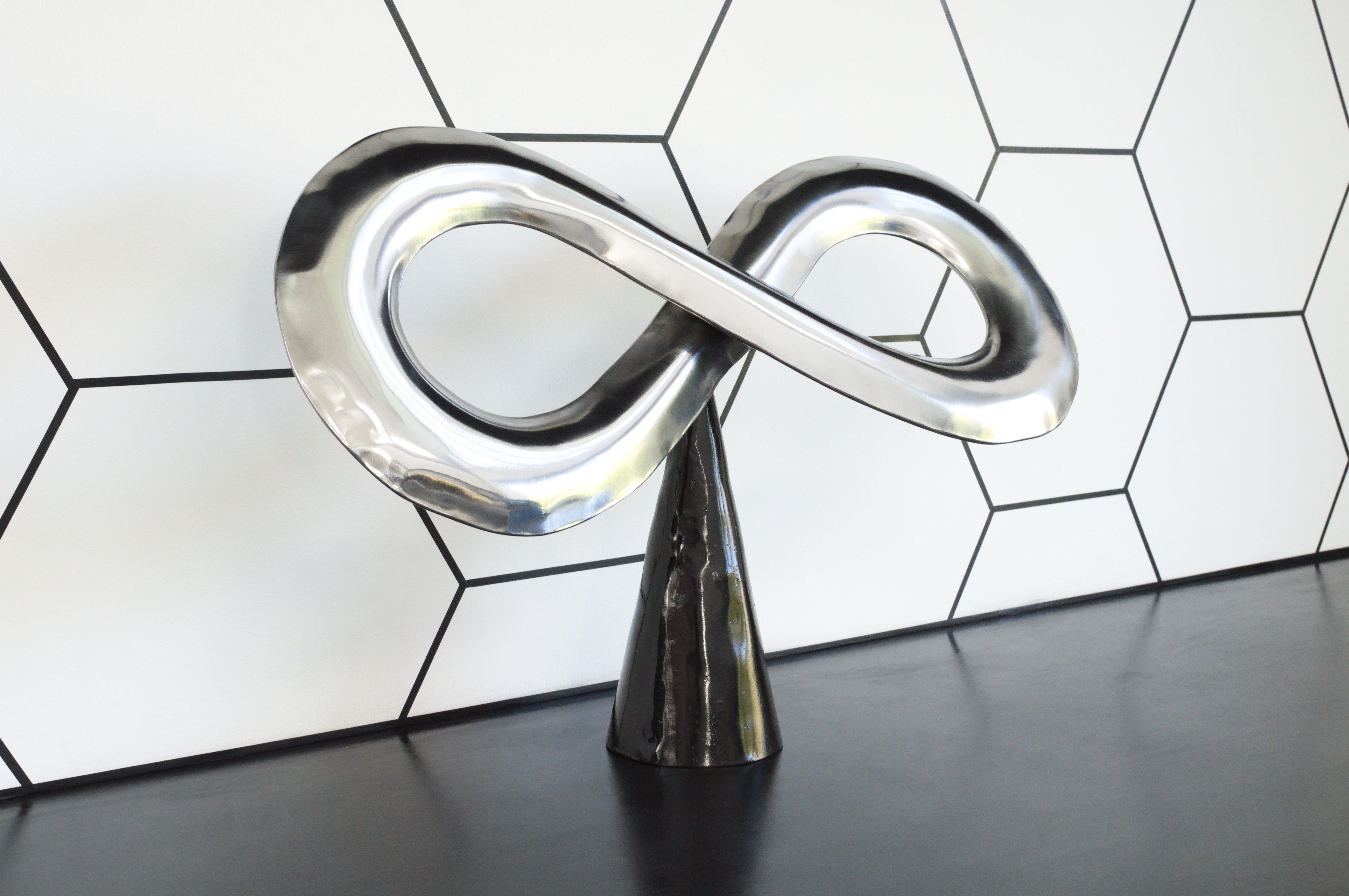 An inflated steel infinity symbol, created using the Hydroforming process. It was created as part of an ongoing exploration of new forms, to discover interesting possibilities and uses for the metal inflation process.

The base is created from