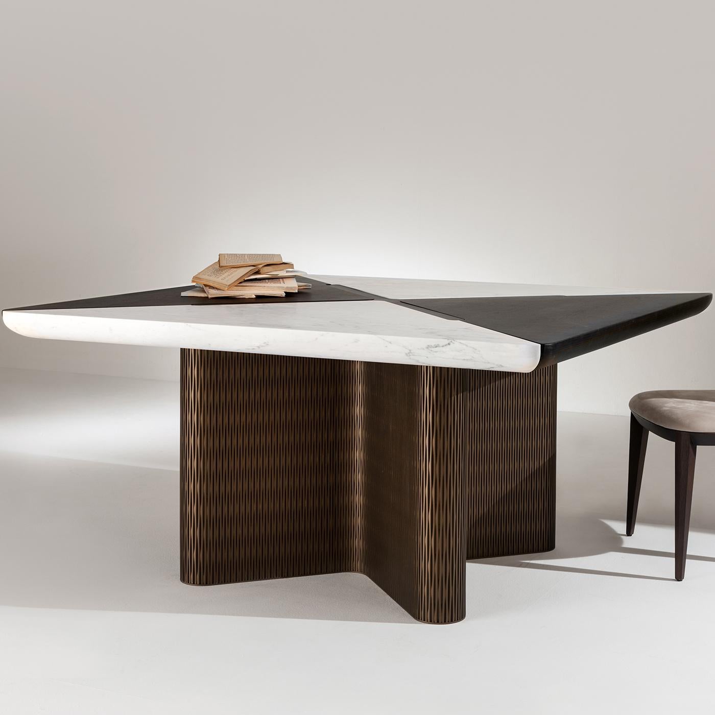 This beautiful square dining table features a table top in four contrasting white and black sections of matte marble. The two rests on a wood structure that is undulating and covered in a bronze lacquer for a metal-like effect. A beautiful piece