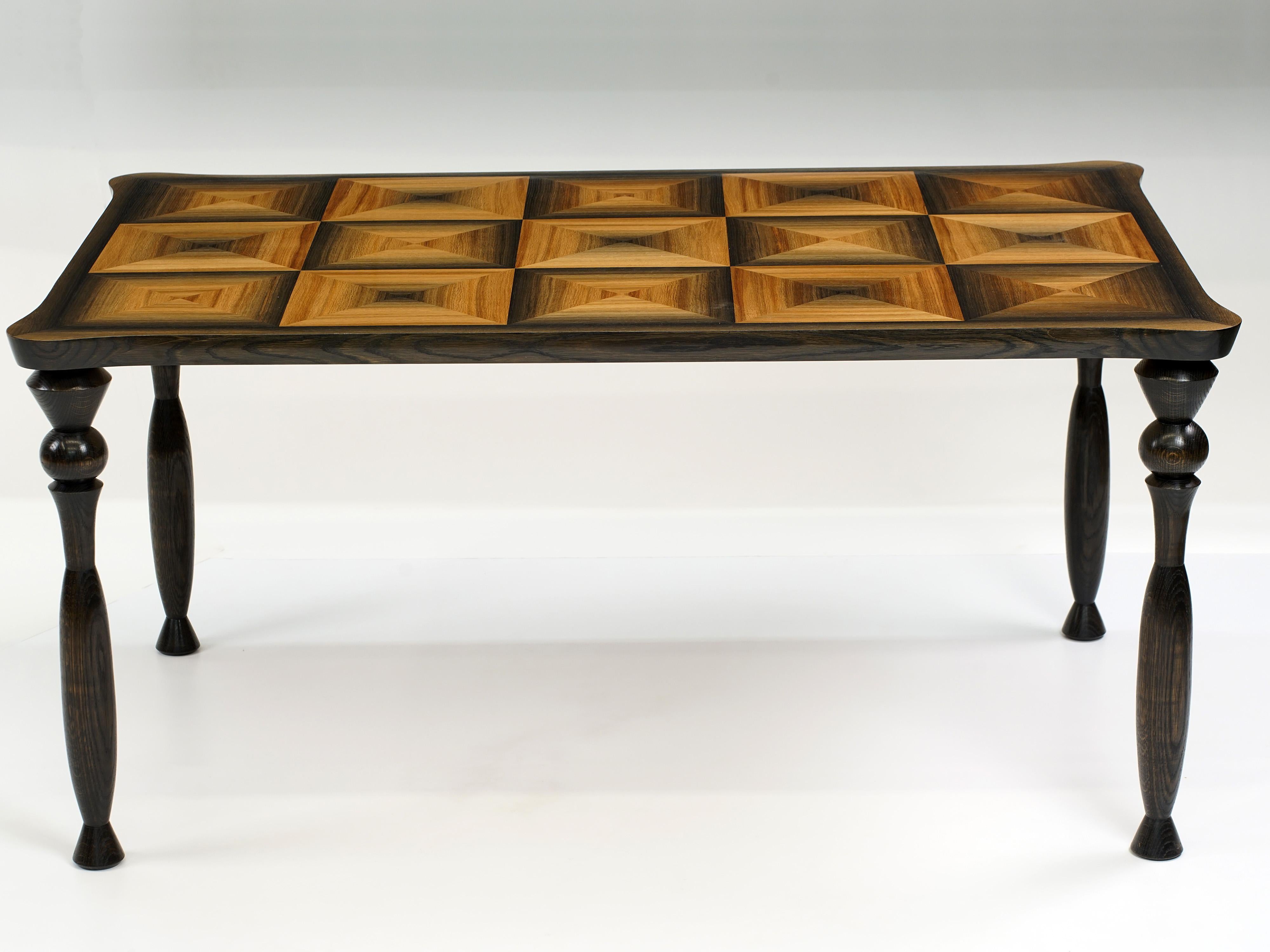 A tabletop is an opportunity to display the beauty of whatever material 
it is fashioned from, and this piece does not disappoint. The striking 
beauty 1200 year old bog oak, sawn into thick veneers and arranged in a 
marquetry pattern of squares