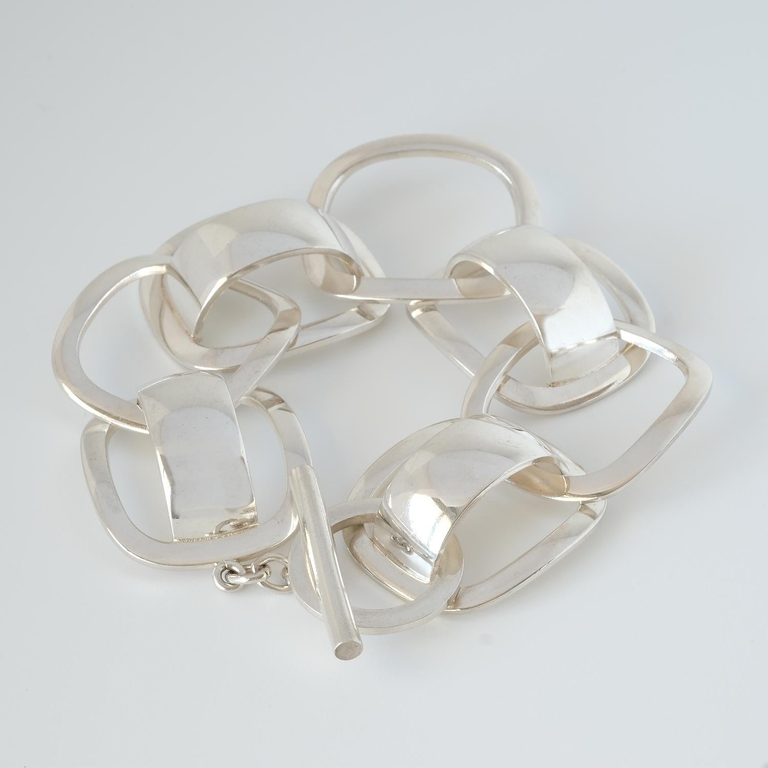 This sterling silver bracelet, with its pierced geometric links, drops down majestically on the wrist. The style of this bracelet is a good example of what is usually called modernist jewelry.

The bracelet is perfect for any casual or festive