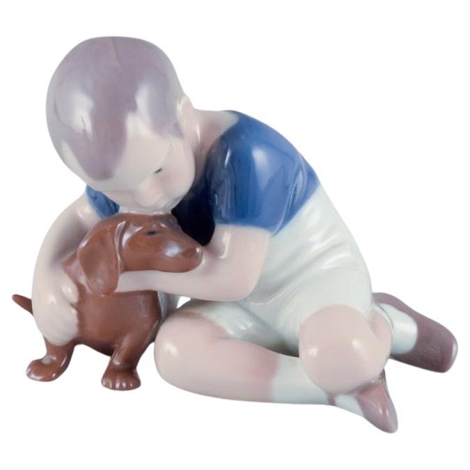 Ingeborg Plockross Irminger for Bing & Grøndahl, figurine of a boy with a dog For Sale