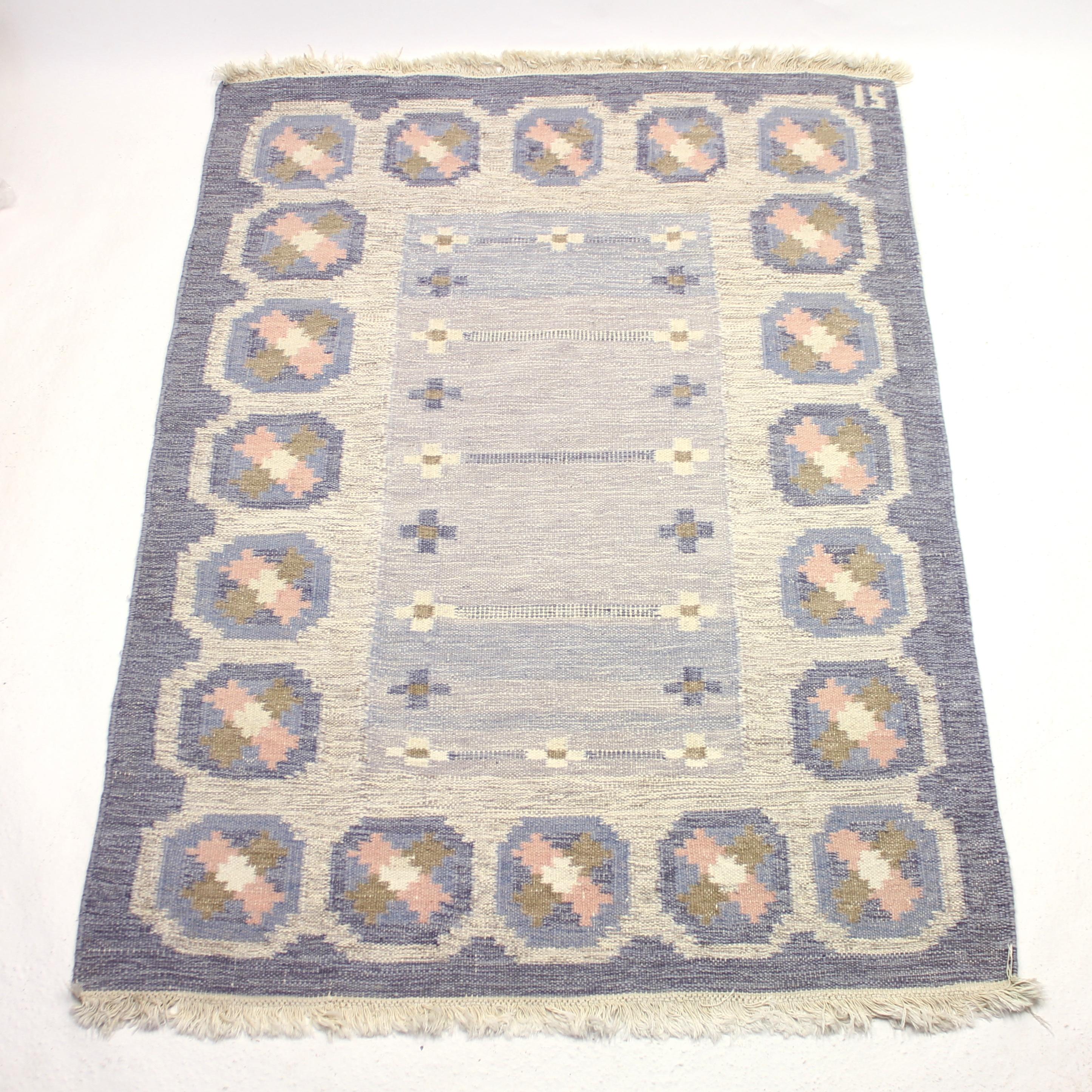 Swedish flat weave Röllakan carpet/rug from the 1950s by Ingegerd Silow. Signed IS in the upper right corner. Main colours are different hues of blue with a dose of grey, green, pink and white. The pattern consists of a blue frame and rectangular