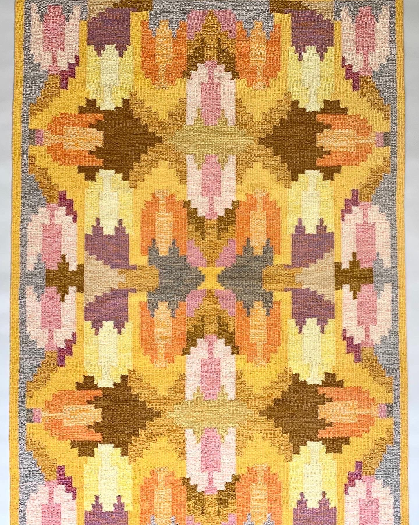 Very rare Ingegerd Silow rug with tulip pattern in a beautiful color palette, hand-woven in Sweden in the 1950s. 

Beautiful color palette in yellow, orange, purple, pale pink, brown and gray in an almost kaleidoscopic pattern with tulips.
