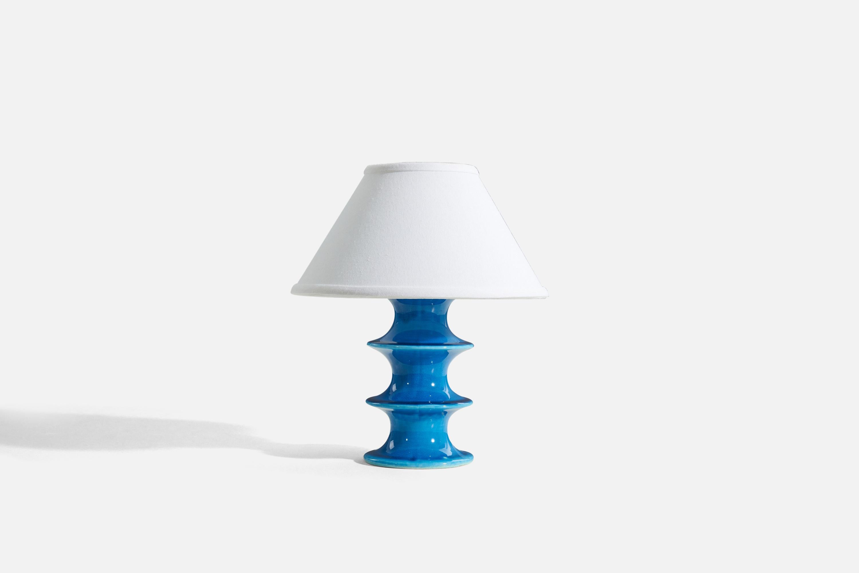 A blue glazed stoneware table lamp designed by Inger Persson, produced by Rörstrand, Sweden, 1960s. Marked.

Sold without lampshades.
Dimensions of lamp (inches) : 8.4375 x 4.375 x 4.375 (H x W x D)
Dimensions shade (inches) : 4.5 x 10.25 x