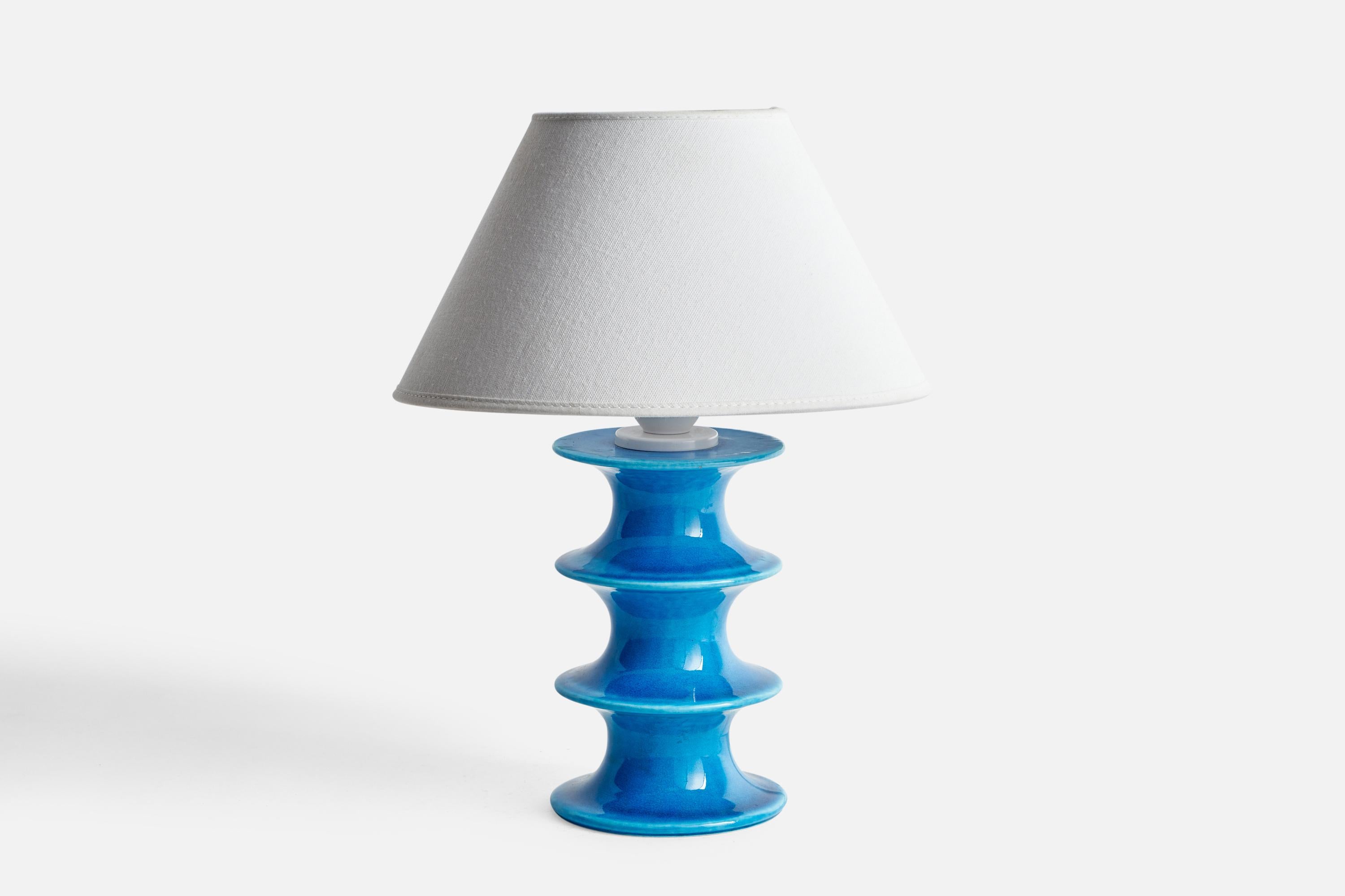 A blue-glazed stoneware table lamp designed by Inger Persson and produced by Rörstrand, Sweden, 1960s.

Dimensions of Lamp (inches): 9.45” H x 4.3” Diameter
Dimensions of Shade (inches): 4.5” Top Diameter x 10” Bottom Diameter x 5.25” H
Dimensions
