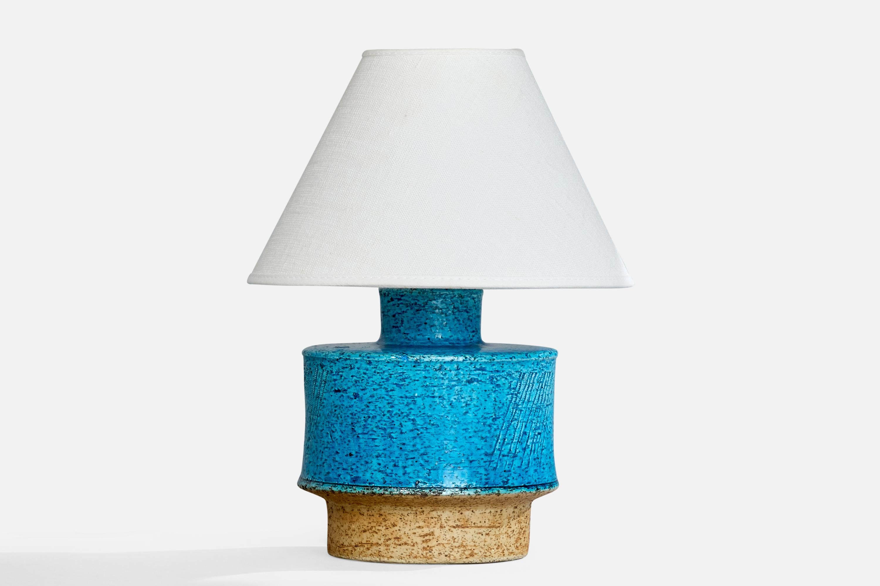 A blue and beige-glazed stoneware table lamp designed by Inger Persson and produced by Rörstrand, Sweden, c. 1960s.

Dimensions of Lamp (inches): 7.75” H x 5.25” Diameter

Dimensions of Shade (inches): 3.25” Top Diameter x 8” Bottom Diameter x 5.5”