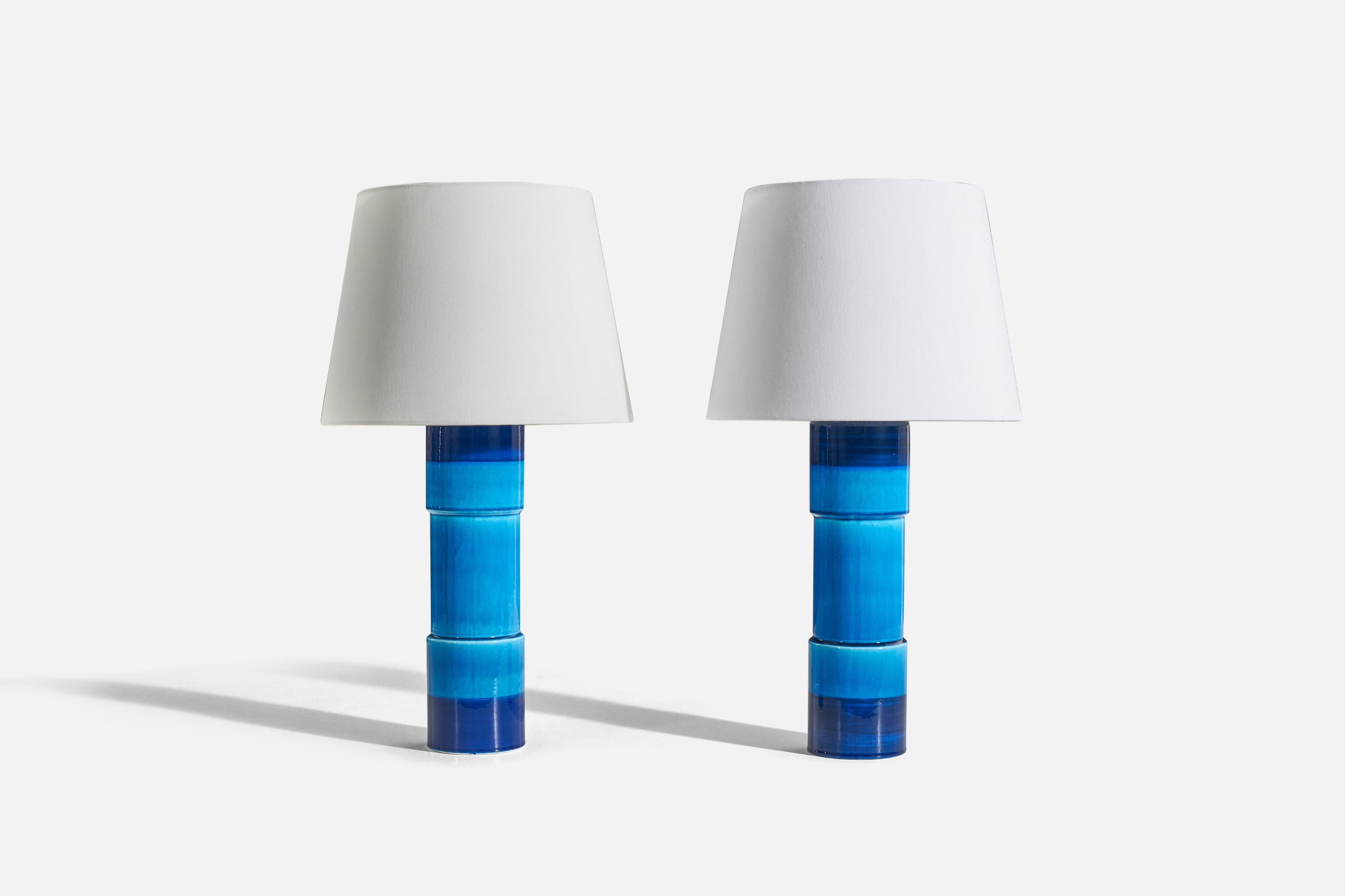A pair of blue-glazed stoneware table lamp designed by Inger Persson and produced by Rörstrand, Sweden, c. 1960s.

Sold without lampshade. 
Dimensions of Lamp (inches) : 16.25 x 4 x 4 (H x W x D)
Dimensions of Shade (inches) : 9 x 12 x 9 (T x B