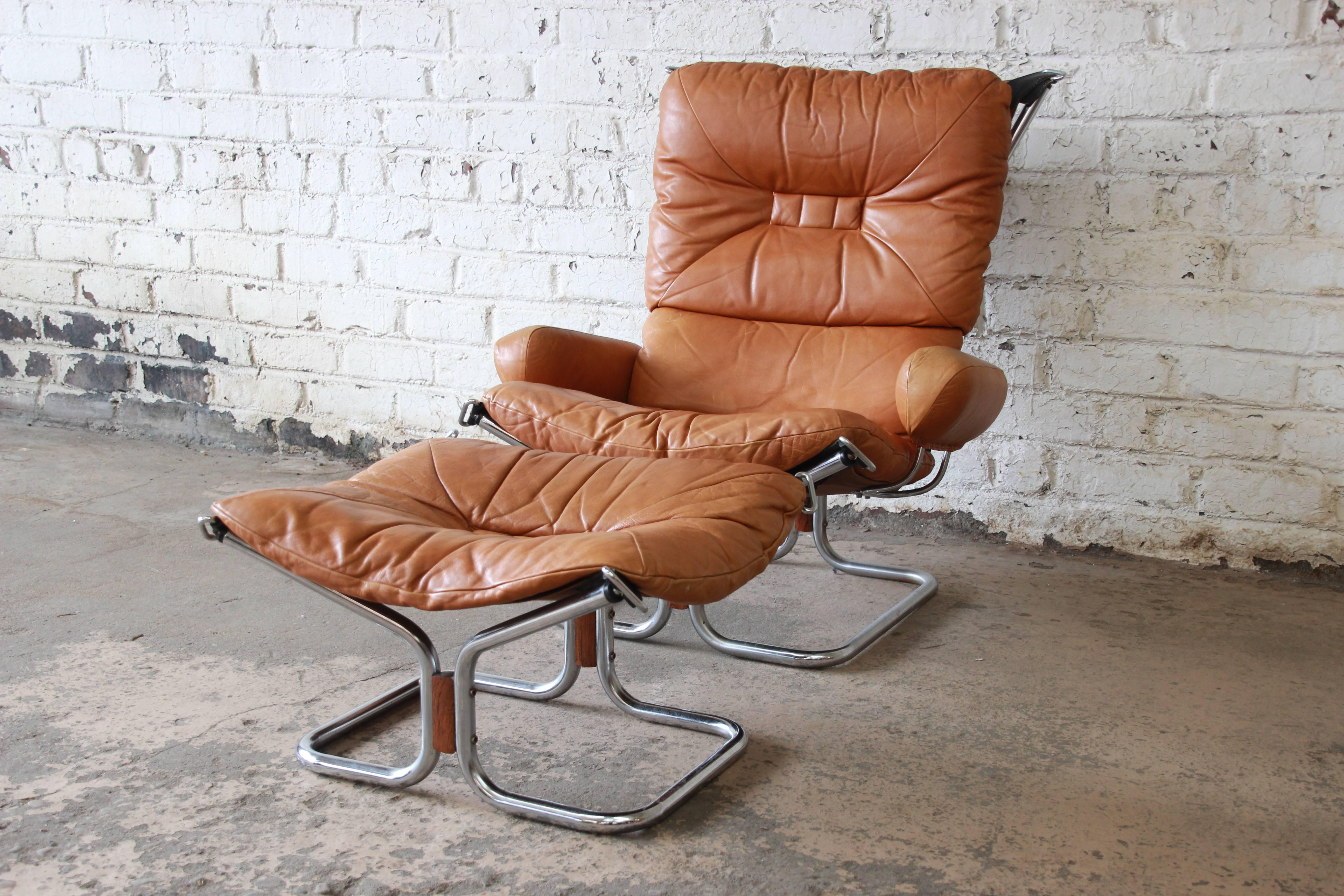 An outstanding Scandinavian Modern brown leather and chrome lounge chair and ottoman designer by Ingmar Relling for Westnofa. The chair features beautifully aged soft brown leather upholstery, a sleek chrome frame, and nice rosewood accents. A very