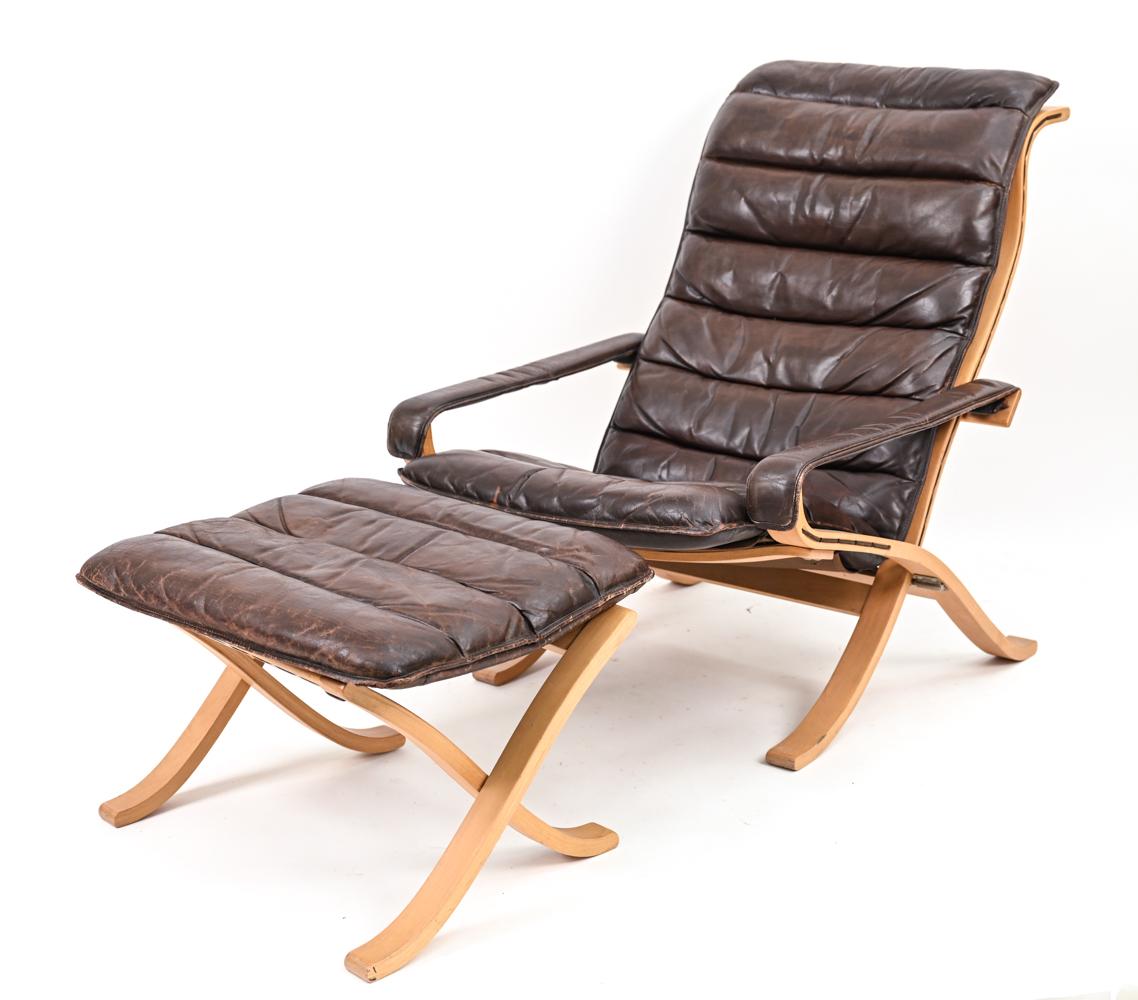A beautiful, sculptural Scandinavian modern lounge chair and matching ottoman designed by Ingmar Relling for Westnofa, Norway, 1970's. Featuring sling arms and a sling seat, upholstered in rich chocolate handsomely patinated leather with an unusual