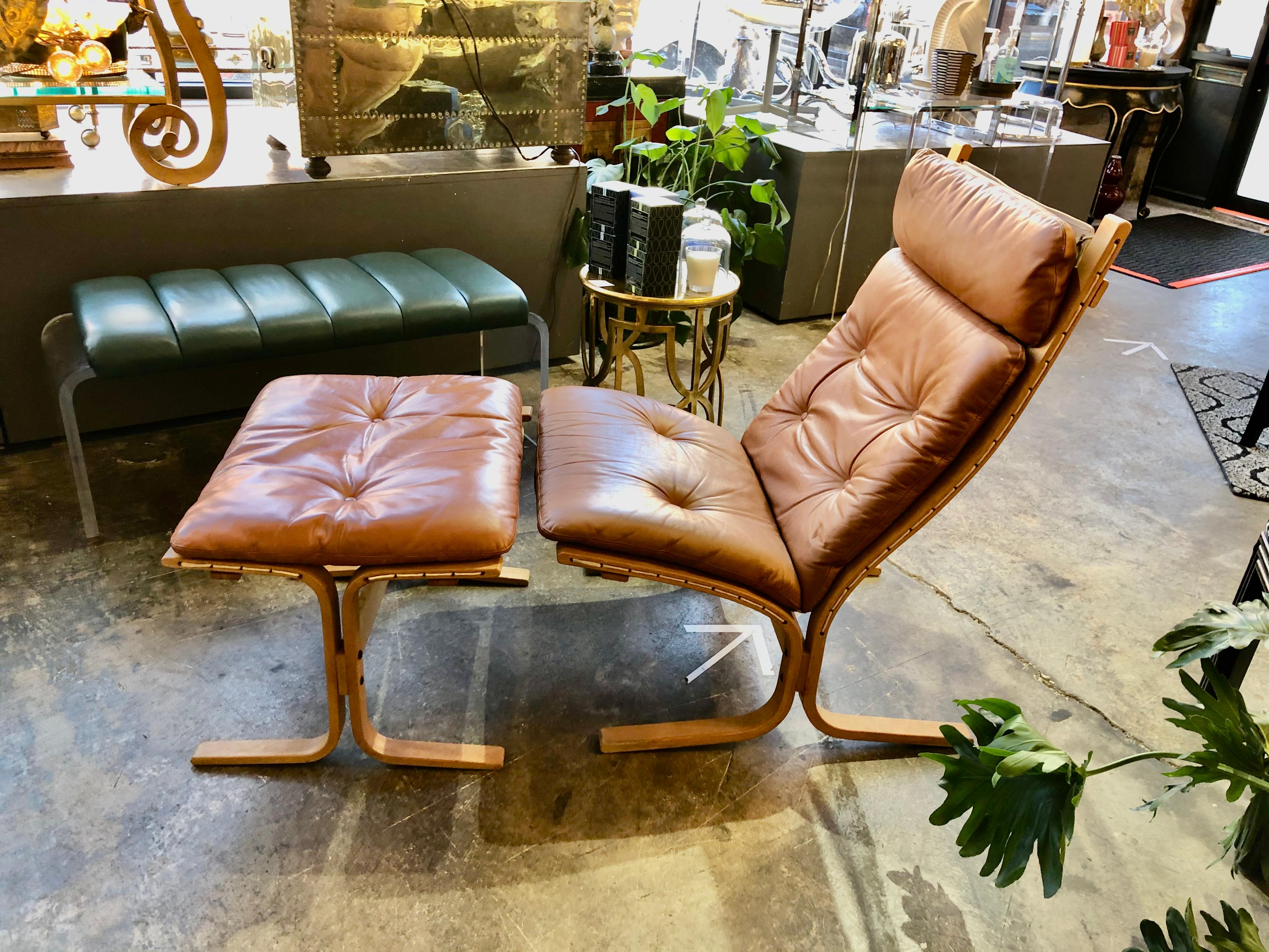 An iconic midcentury Ingmar Relling for Westnofa teak, leather and canvas siesta lounge chair and ottoman.