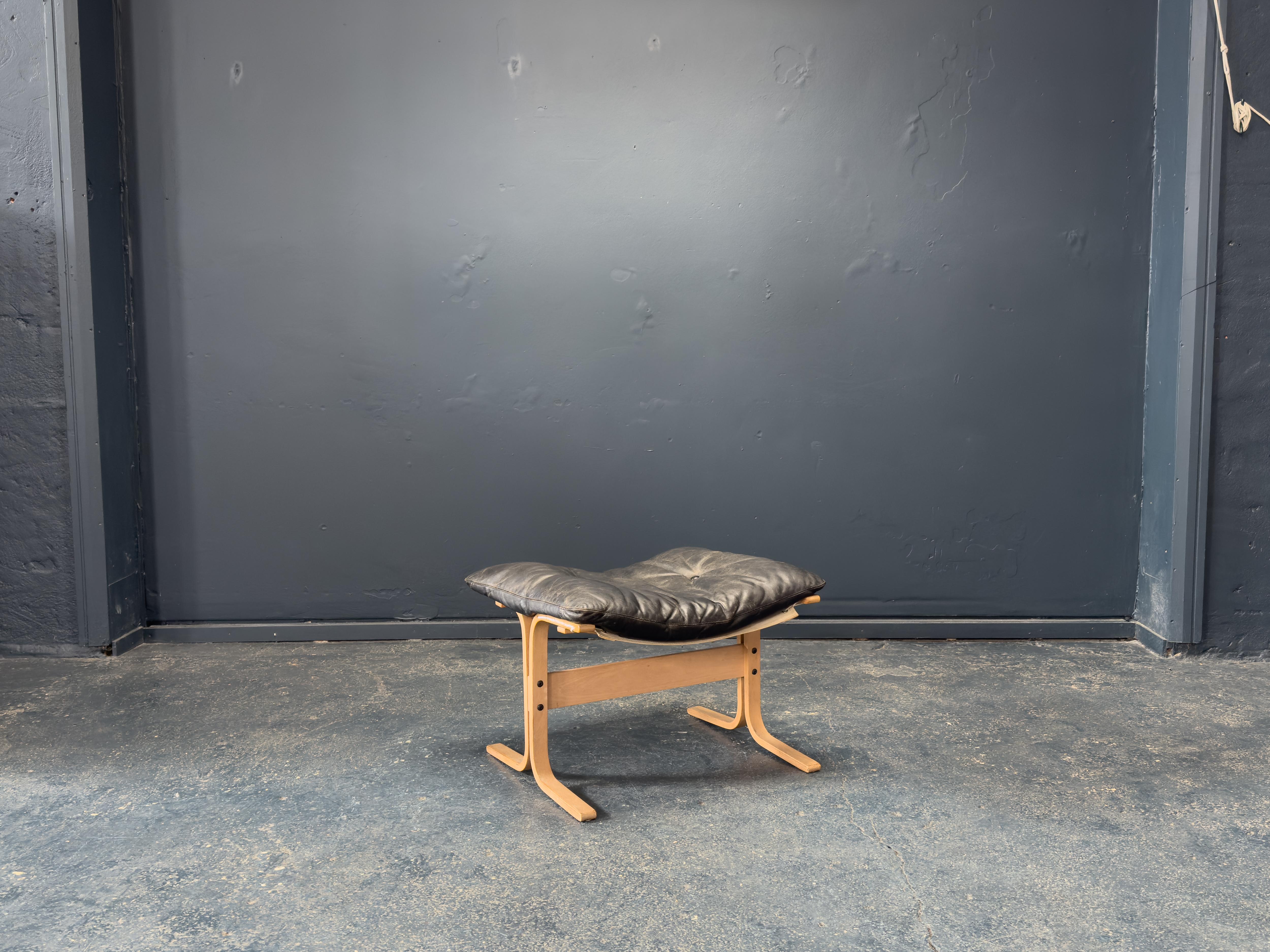 Este reposapiés de piel de Ingmar Relling es un ejemplo clásico del diseño modernista noruego, que combina la comodidad con un refinado sentido de la sencillez. Con un armazón de madera curvada de haya clara, la base muestra la silueta en forma de