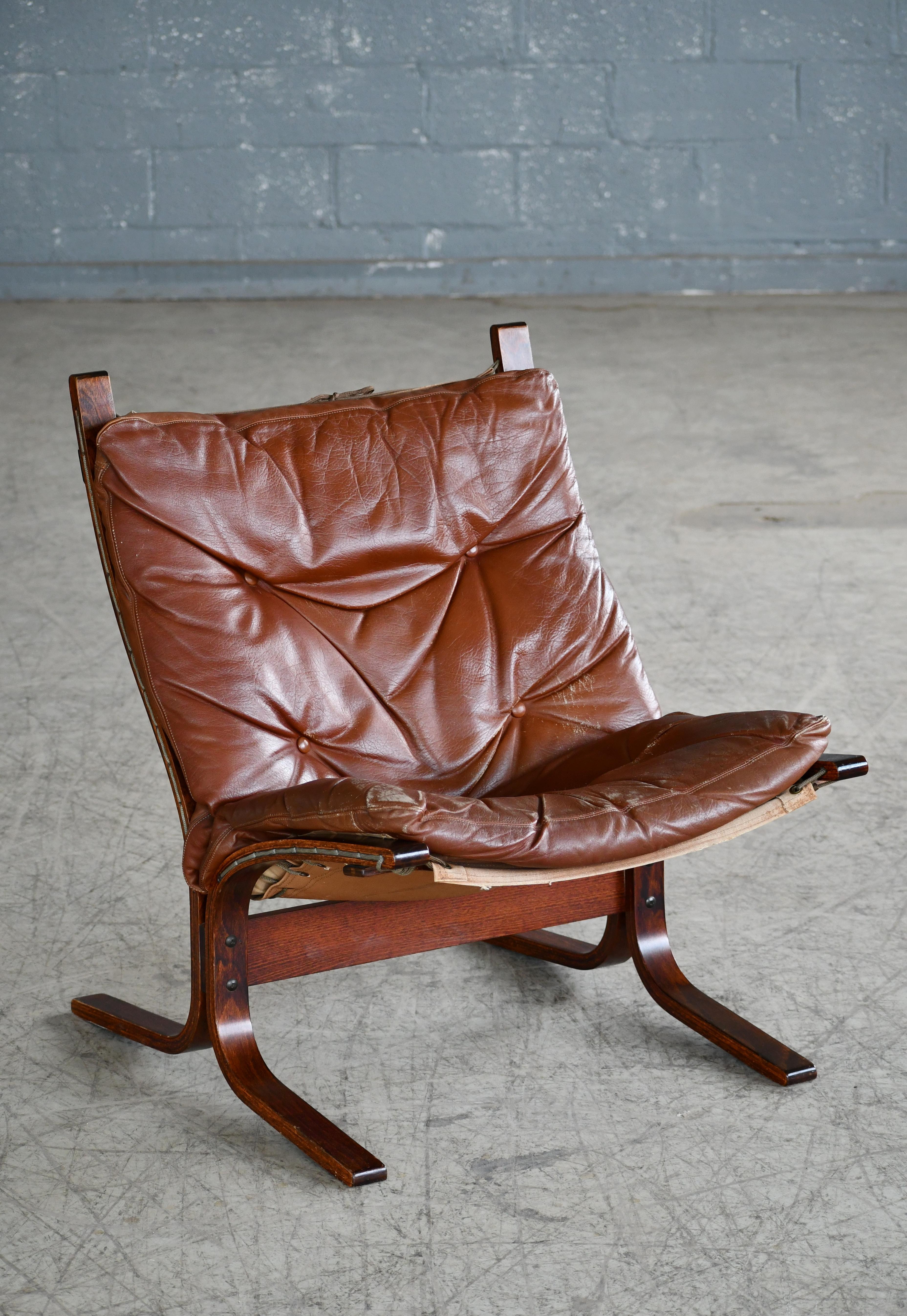 Siesta sling chair by iconic Norwegian designer Ingmar Relling. Manufactured in the late 1960s by Westnofa. The lounge chair features a jacaranda stained beechwood frame and rich cappuccino brown leather upholstery. This chair has been prized for