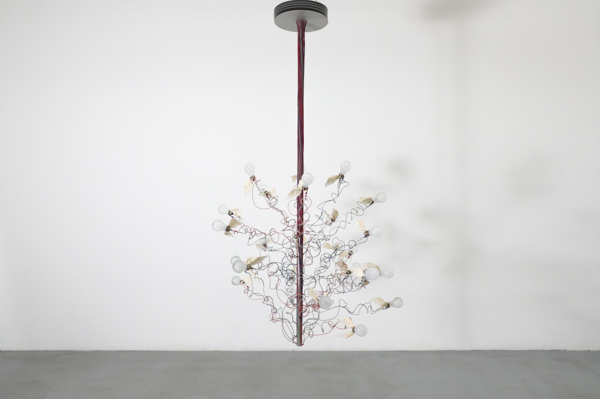 Esta impresionante lámpara de araña del visionario diseñador de iluminación alemán Ingo Maurer es un triunfo del ingenio y la creatividad nacido de las circunstancias: La lámpara de araña Birds Birds surgió en oposición directa a la legislación