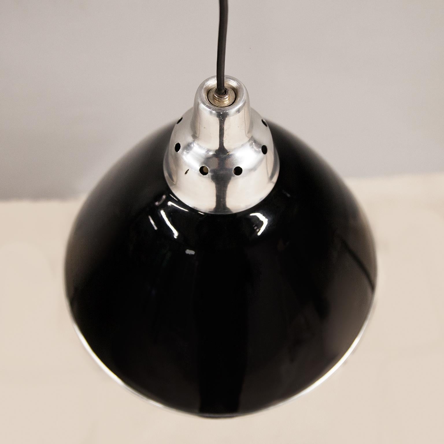 Kegelförmige Pendelleuchte Scheinwerfer entworfen von Ingo Maurer und hergestellt von Design M, Deutschland 1968. Der Schirm ist aus schwarz lackiertem Metall und der Diffusor aus transparentem Kunststoff und hat eine E27-Fassung. Der Scheinwerfer