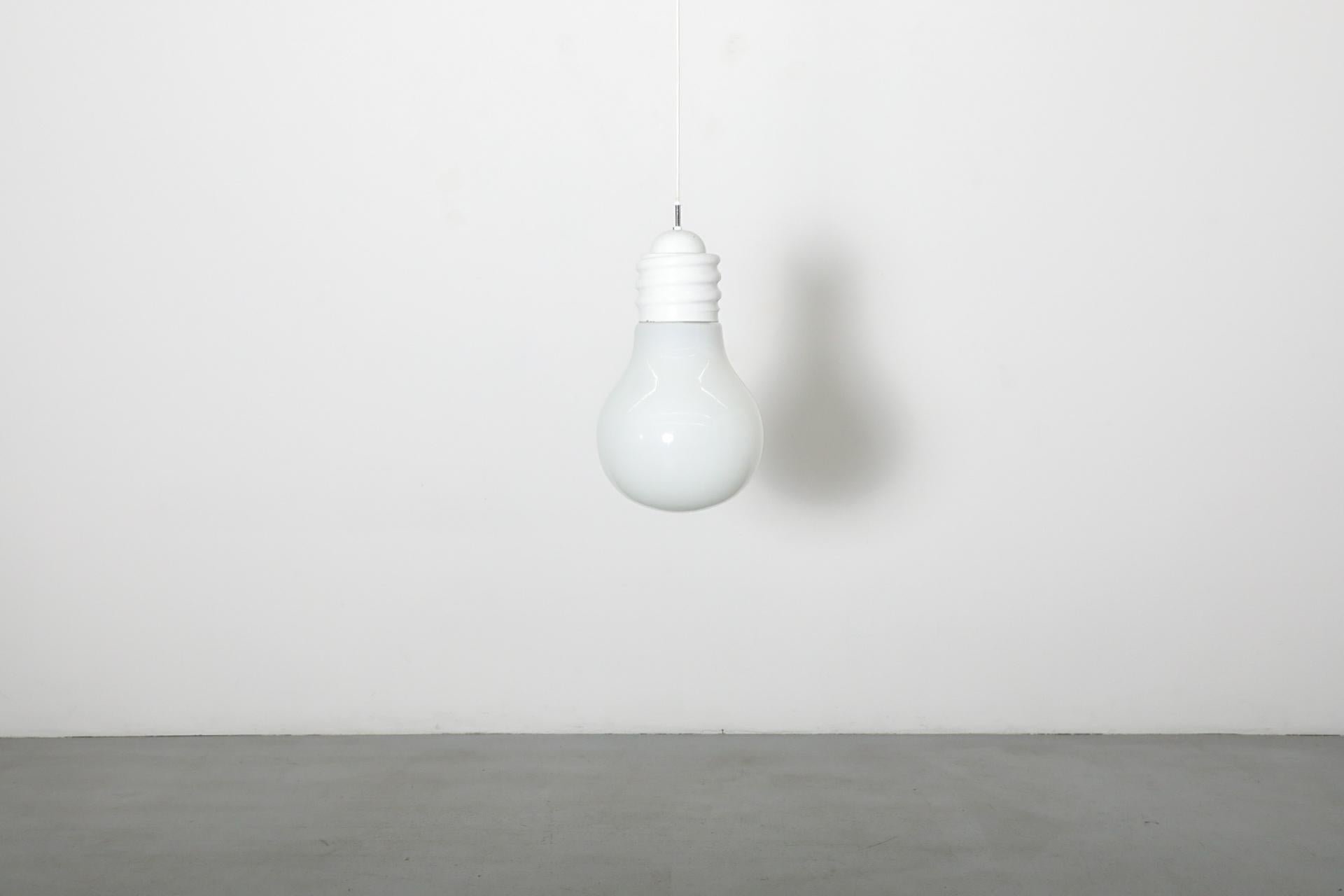 Suspension de plafond à ampoules vintage inspirée par Ingo Maurer. Boîtier en métal émaillé blanc avec un abat-jour en verre de lait en forme de bulbe. En état d'origine avec une usure visible, y compris des rayures et des pertes de peinture.