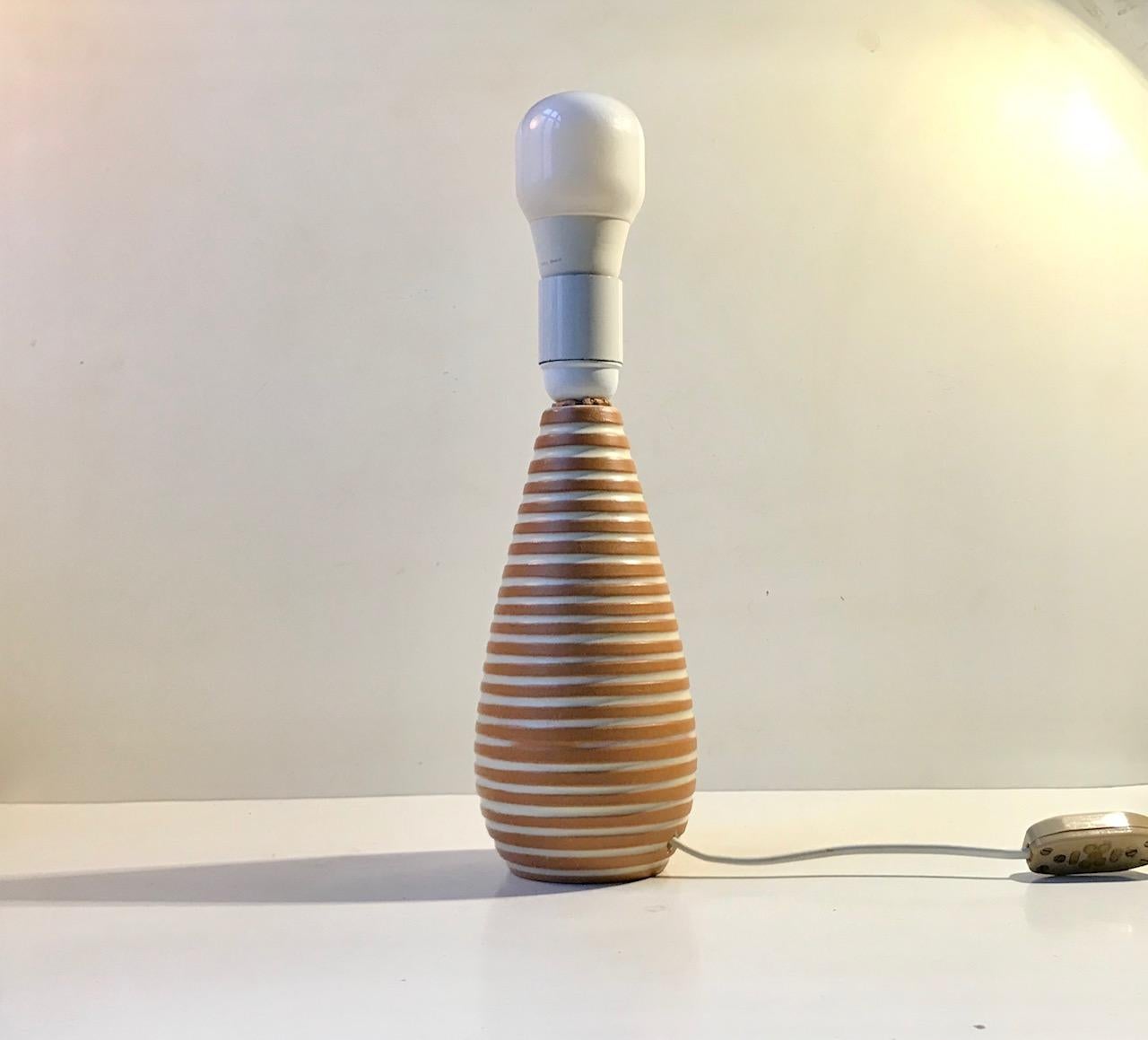 A rare Ingrid Atterberg Terracotta table lamp with white creamy rings. It is called Rondi and was a part of her series Inca from Upsala Ekeby in Sweden. Designed and manufactured during the 1950s. Signed by hand to its base.The shade in the photos