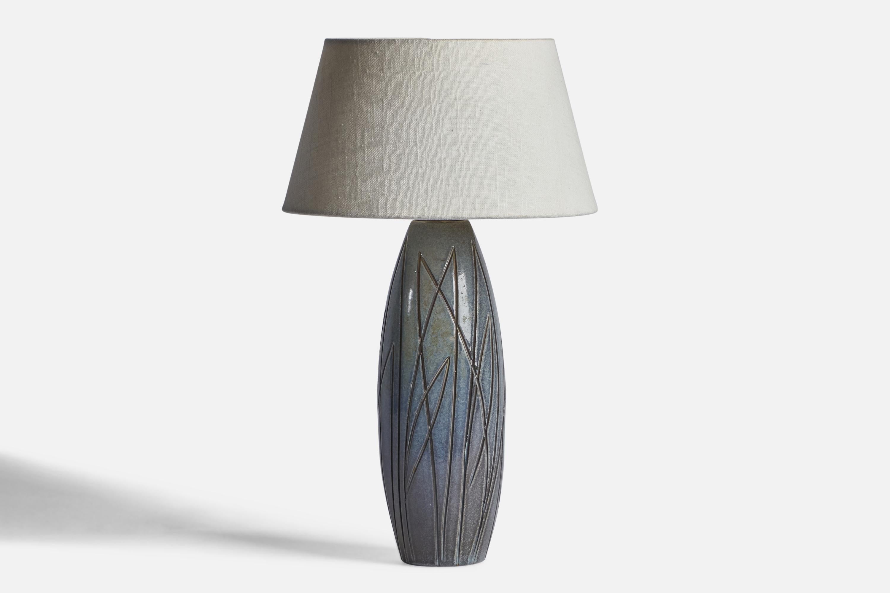 A blue-glazed incised table lamp designed by Ingrid Atterberg and produced by Upsala Ekeby, Sweden, 1950s.

Dimensions of Lamp (inches): 13.5” H x 4.1” Diameter
Dimensions of Shade (inches): 7” Top Diameter x 10” Bottom Diameter x 5.5” H 
Dimensions