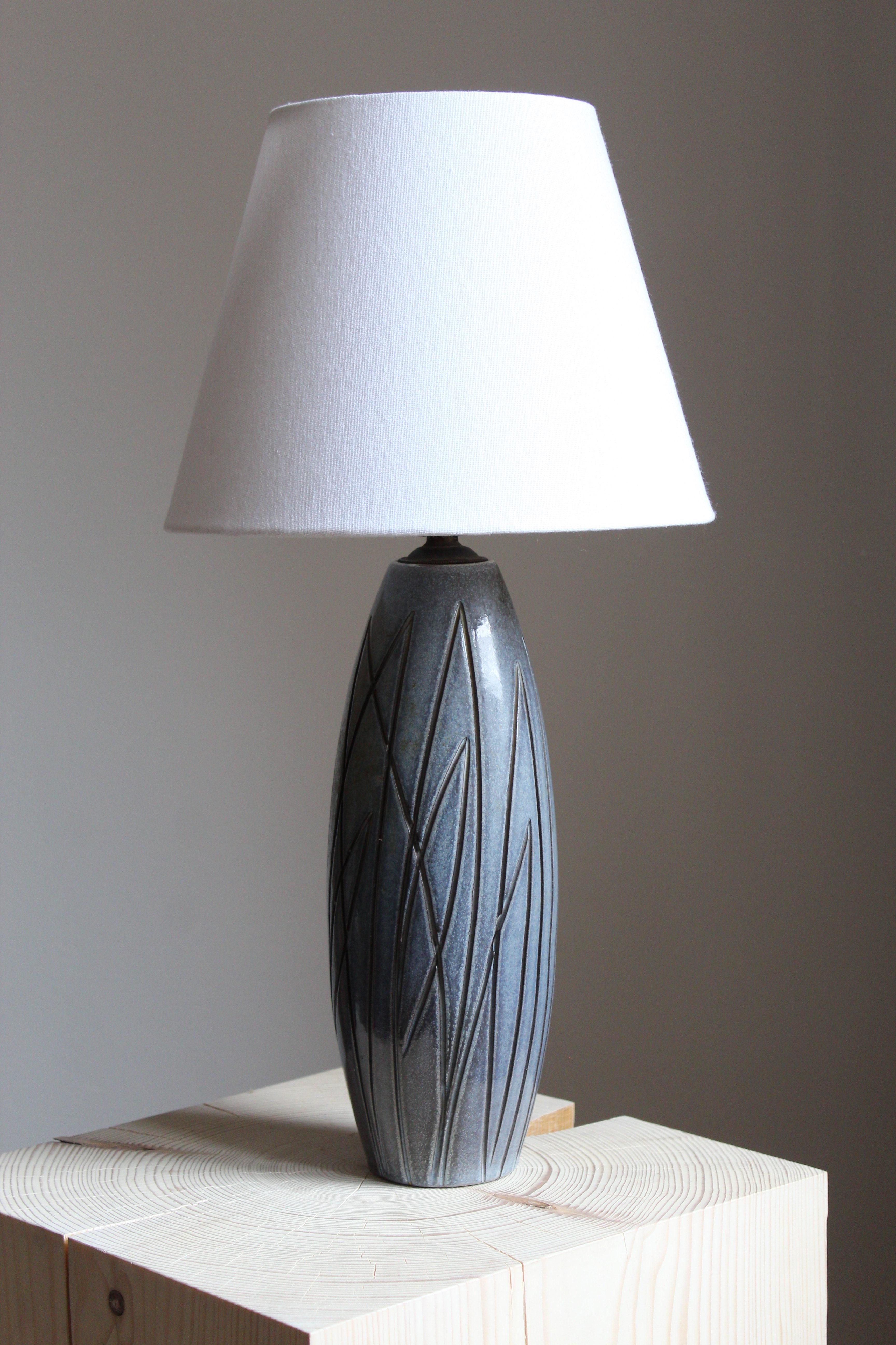 A table lamp, on a ceramic base designed by Ingrid Atterberg for Upsala Ekeby, Sweden, 1950s.

Glaze features a blue color.

Sold without lampshade. Stated dimensions exclude lampshade. Sold without lampshade.