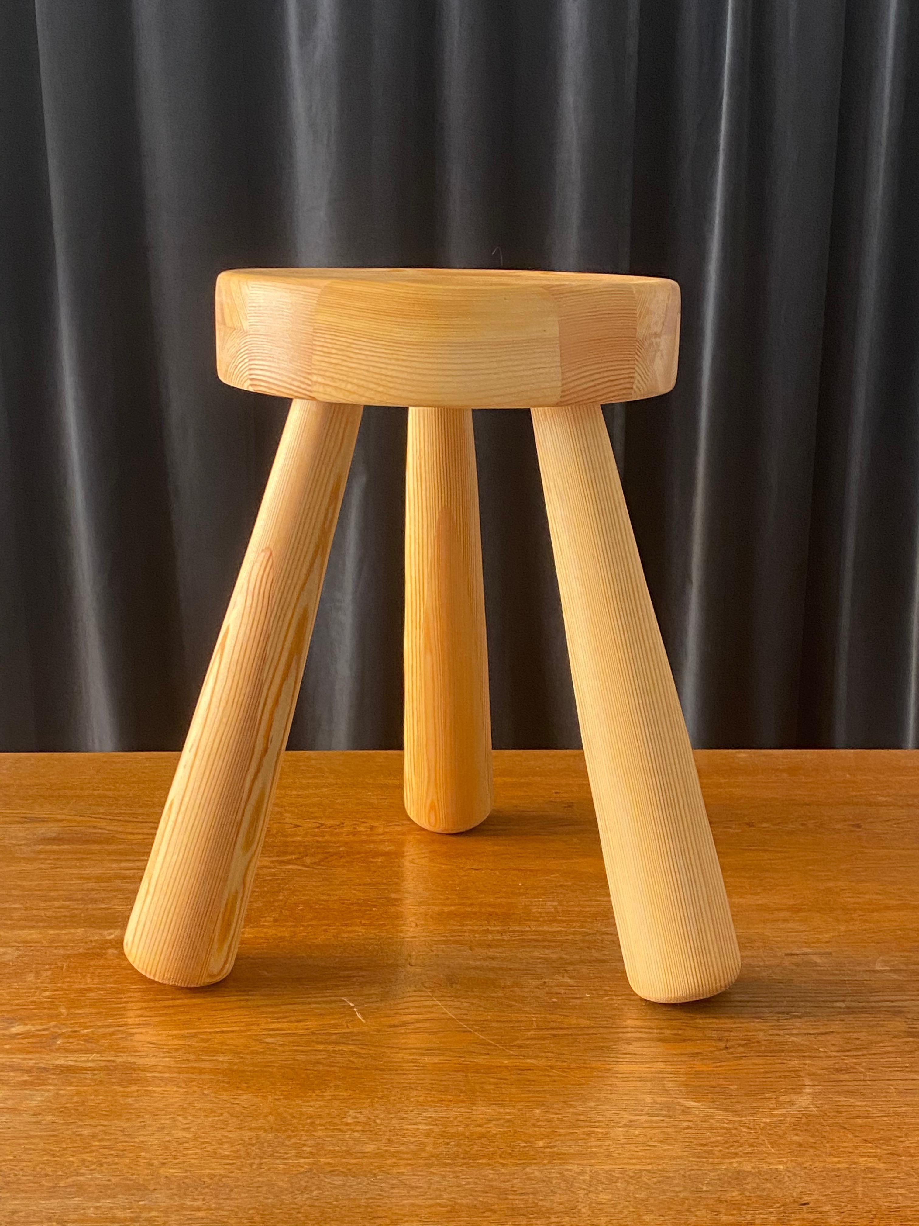 A large and sculptural stool, designed and produced in the studio of Ingvar Hildingsson, Kalmar Läns Slöjdare IH Slöjd Rugstorp. Signed and labeled. In lightly treated pine. Lightly restored and in excellent condition.
