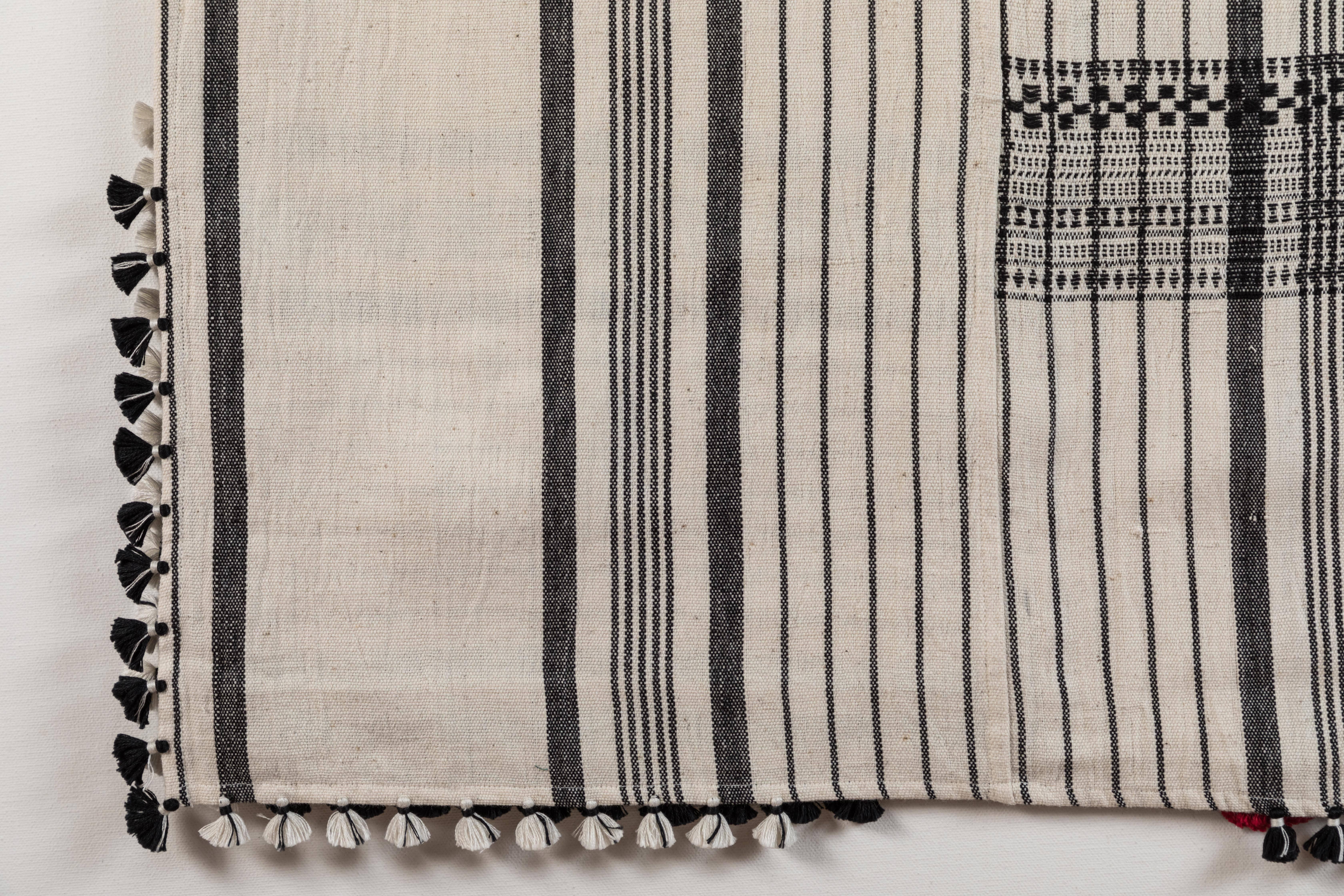 Kala naturally dyed organic cotton from Gujarat, India.  Hand-loomed using traditional Indian textile techniques to produce extra weft woven stripes and plaids.  This black and white bedcover/throw has added hand-knotted tassels. Åreas of hand