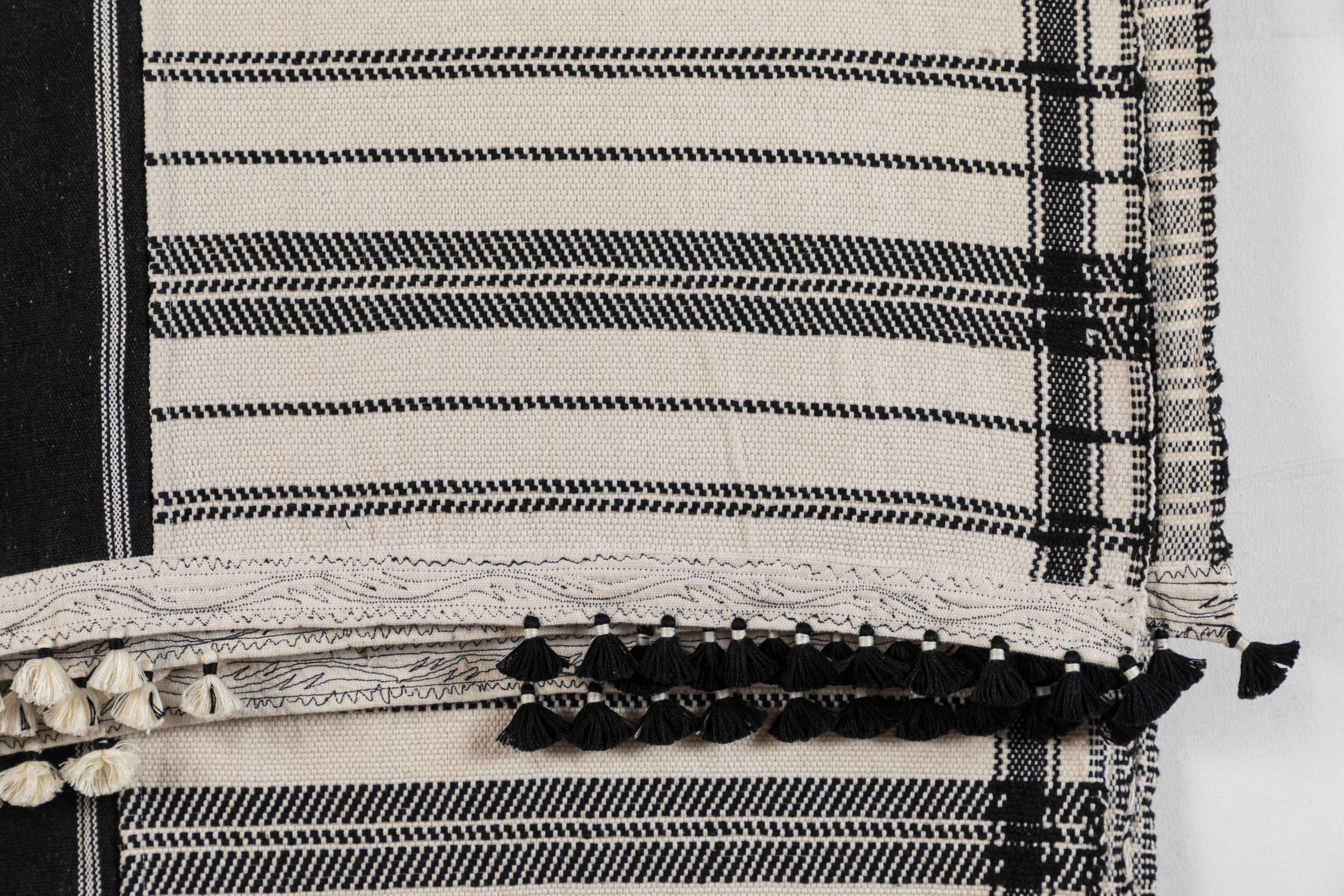 Kala naturally dyed organic cotton from Gujarat, India. Hand loomed using traditional Indian textile techniques to produce supplementary weft woven designs. This black and white bedcover/throw has added hand-knotted tassels.     