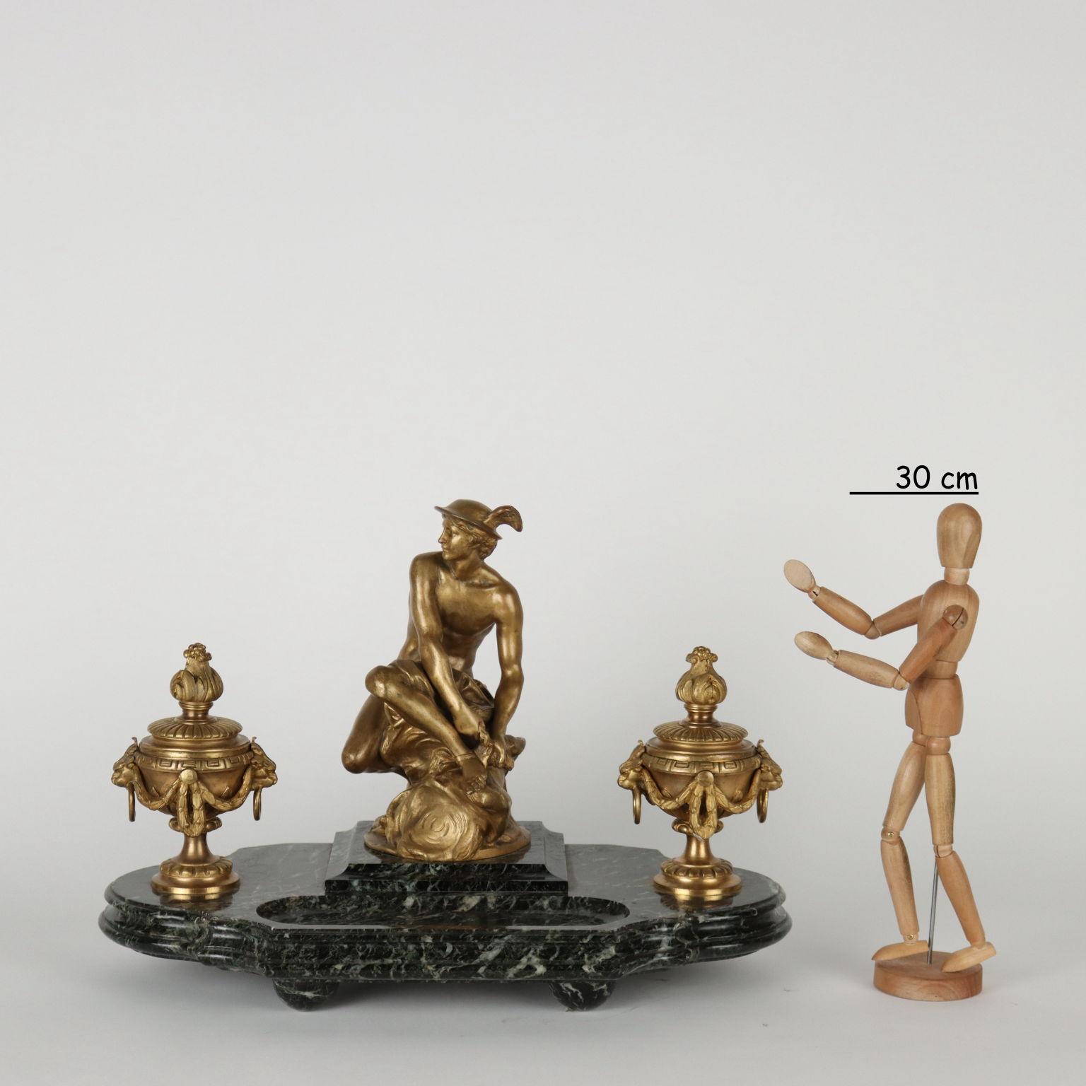 Inkwell with large base in green serpentine marble surmounted by two cup-shaped vases with lids and lion handles with the function of inkwells. In the center, a statue of Mercury with the author's engraved signature. The bronzes are gilded and have