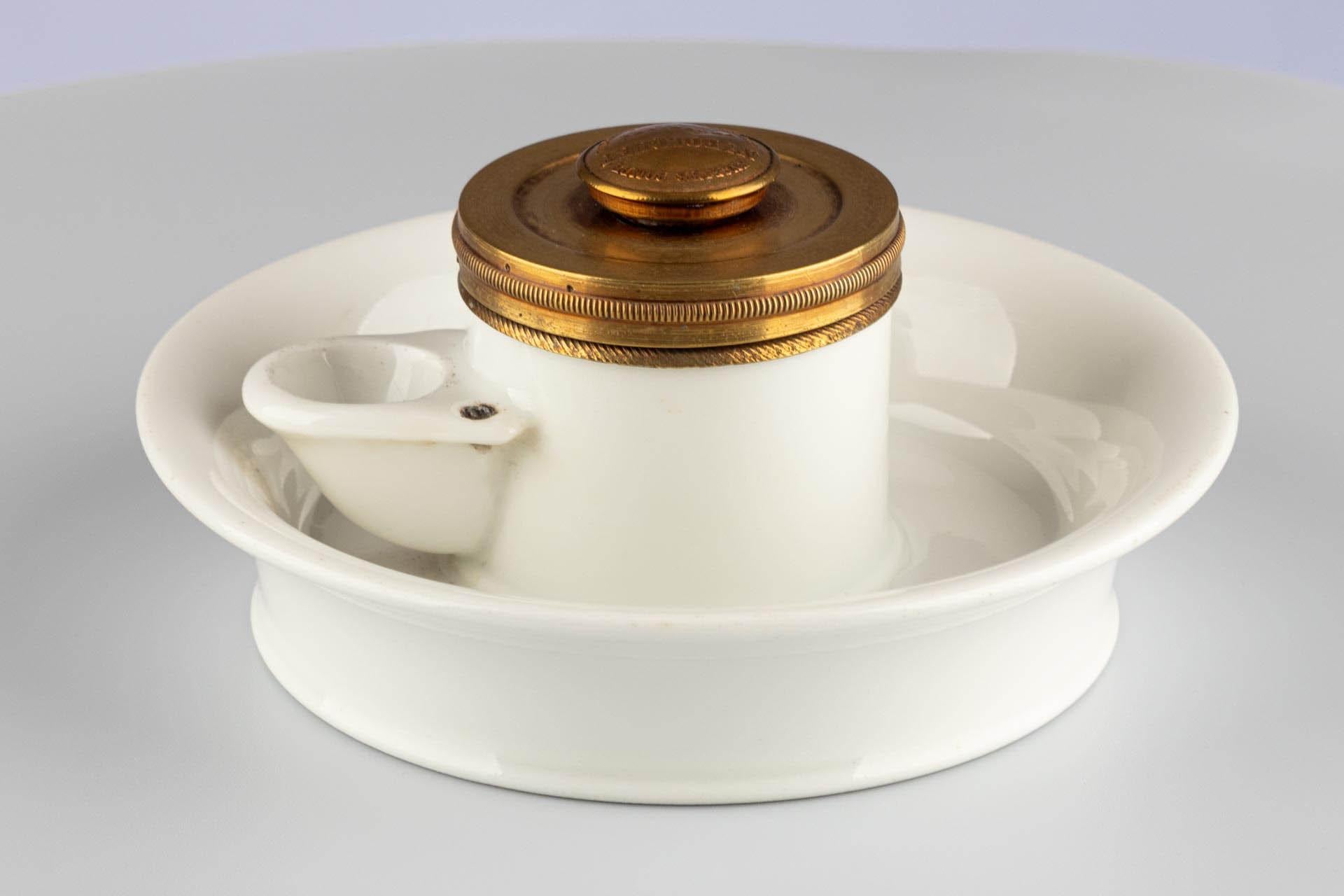 Encrier avec mécanisme de pompe intégré

Origine : France
Matière : Laiton, porcelaine, métal nickelé
Date : Circa 1900

Dimensions :
H × Ø : 8 × 14 cm

Description :
Cet encrier français datant d'environ 1900 se distingue par sa construction