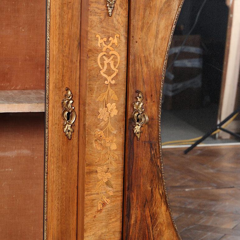 English Victorian figured walnut breakfront side cabinet or credenza with a centre mirrored door flanked with glass display cabinets. The piece is accented with gilt mounts and features floral inlay to the frieze as well as inlaid stringing to the
