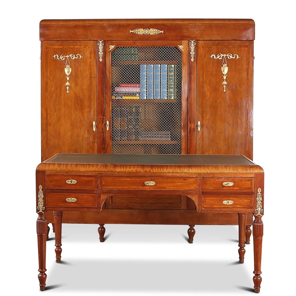 An Art Deco three-door bookcase in mahogany, with inlaid banding and fine ormolu mounts, the centre door with gilt mesh and glass, the outer two veneered in mahogany and with ormolu details. 




 