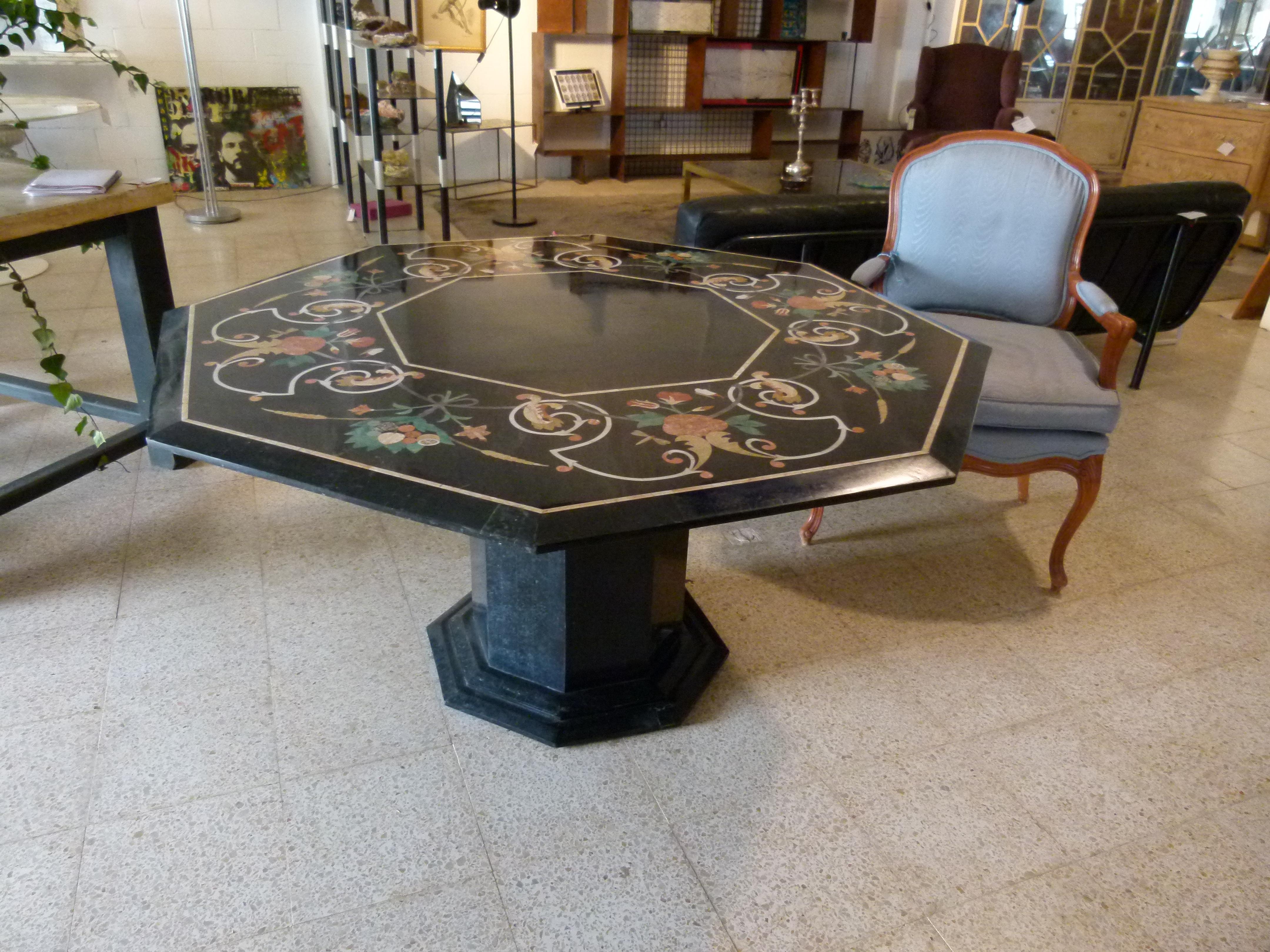 Black marble table in octagonal shape, from France. Black color with floral valance inlaid in green white and orange colors. Center solid base that allows 8 diners to seat comfortably.