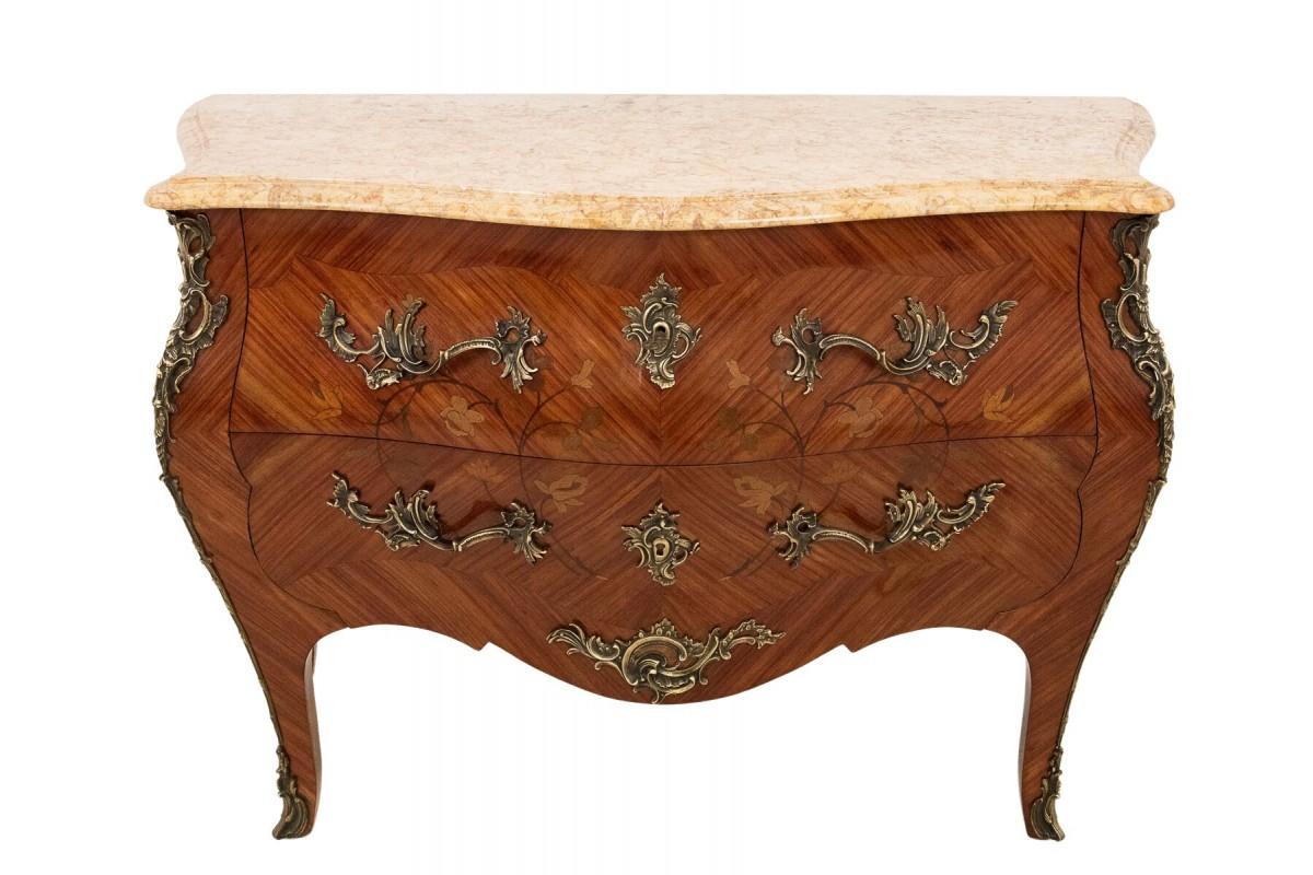 Die Kommode mit Intarsien und Marmorplatte im Louis-XV-Stil stammt aus Frankreich an der Wende vom 18. zum 19. Jahrhundert. Eingelegte florale Motive und Kupferornamente sind charakteristische Elemente des Stils von Louis XV (1730-1760).