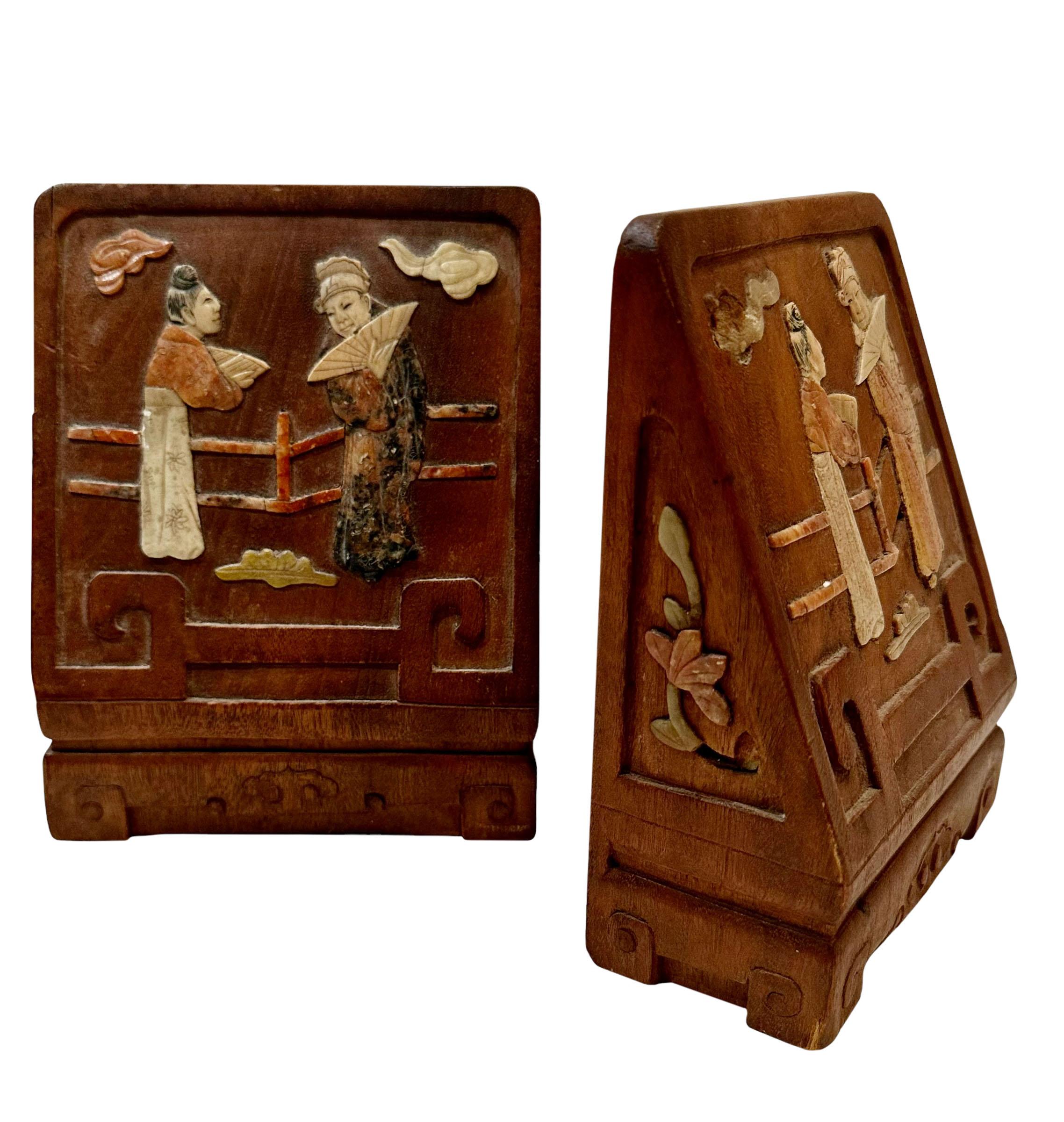Ein Paar chinesische geschnitzte Teakholz-Buchstützen aus den 1920er Jahren, die mit Speckstein eingelegt wurden, der ebenfalls mit Mustern geschnitzt wurde. Auf der Rückseite befindet sich ein Etikett, möglicherweise für den Import.