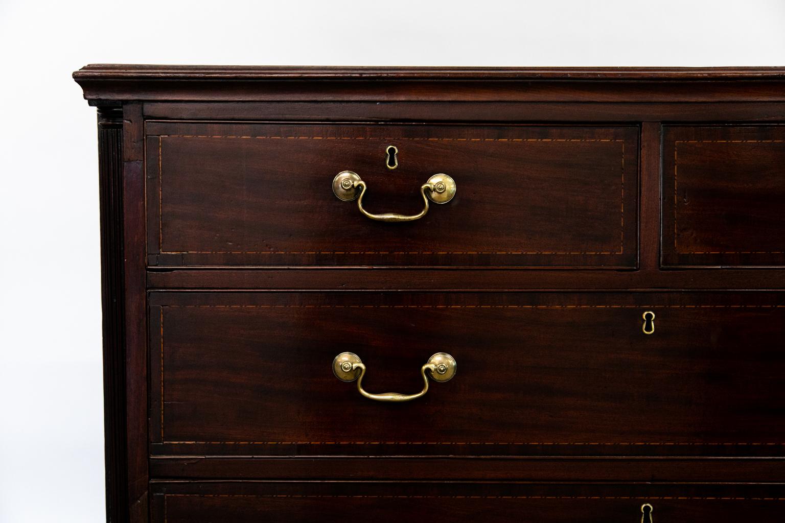 The drawers of this chest are crossbanded with mahogany and inlaid with boxwood and ebony. The corners have a fluted corner column and the base has the original ogee feet.