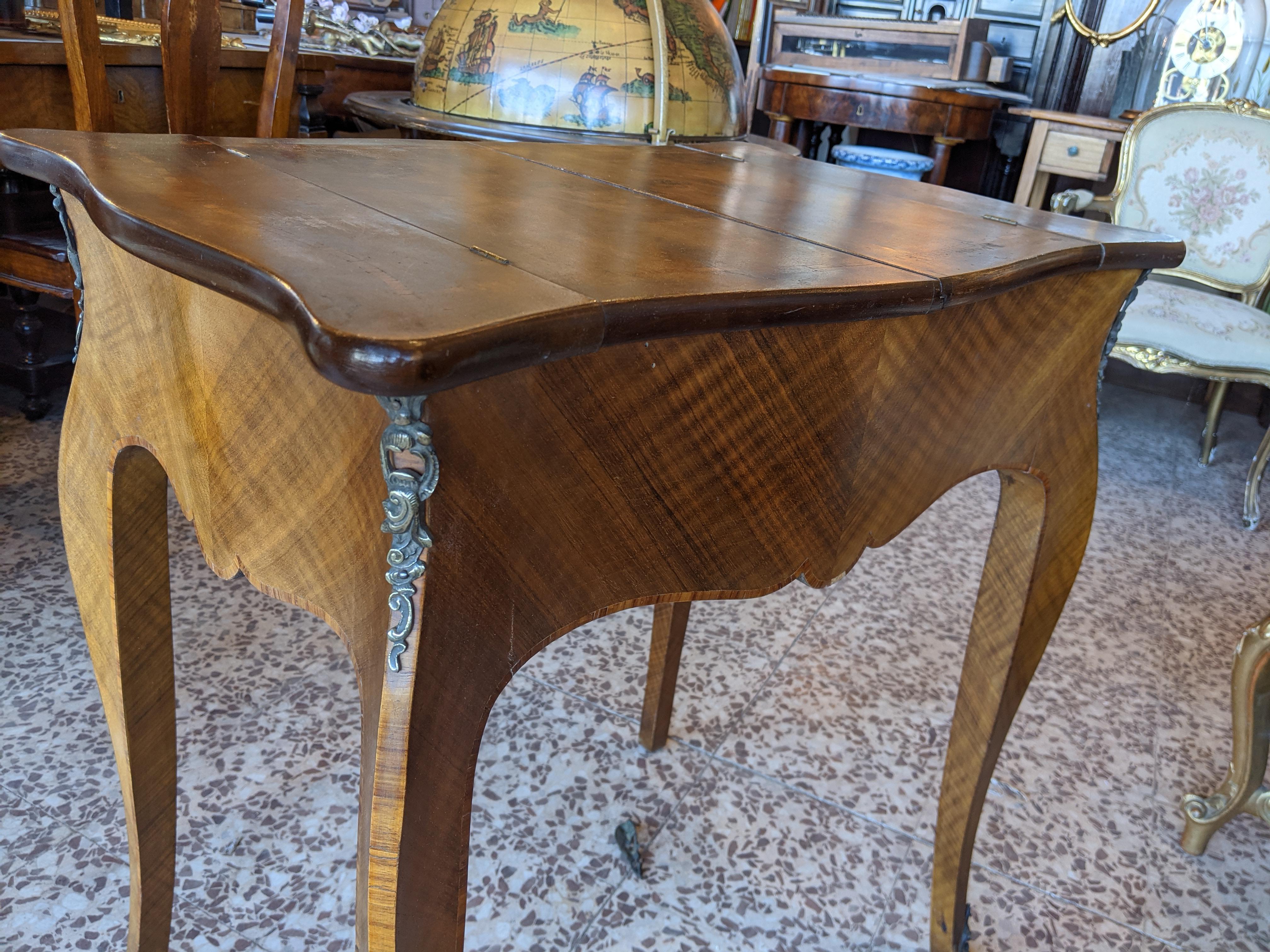 Inlaid table with opening on the top from which it is possible to access the contents of the drawer. In solid walnut, walnut burl and bois de rose. With brass decorations. Late 1800s

Please note that all of our items are shipped after a microwave