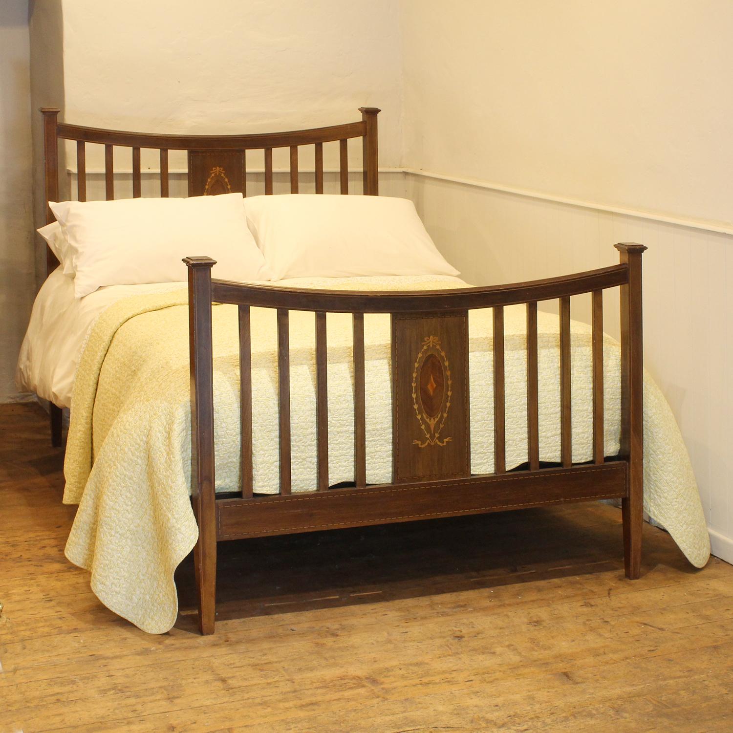 An Edwardian slatted bed in mahogany with fruitwood inlay work.

This bed accepts a standard double, 4ft 6in (54 in), base and mattress set, with a slight overlap.

The price is for the bed frame and a firm bed base. 

The mattress, sprung bed