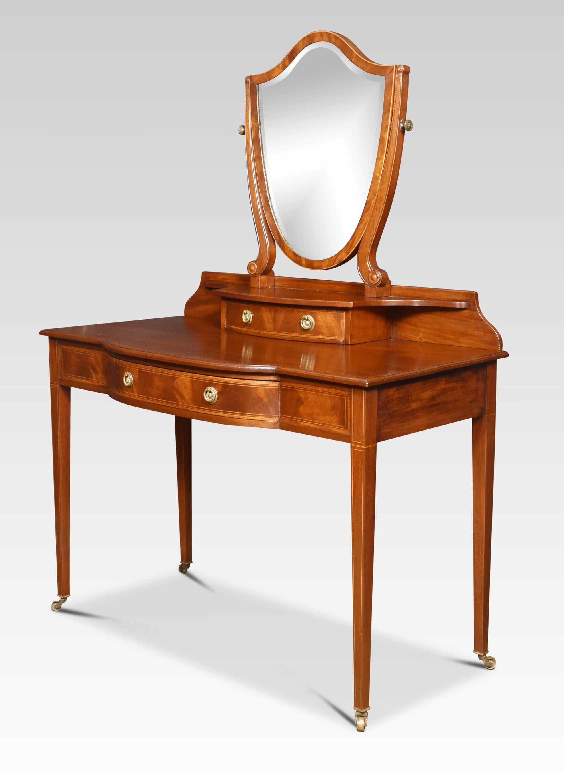 Mahogany dressing table the original bevelled mirror plate in a moulded sheild shaped frame between shaped supports with a short drawer below. To the large mahogany, bow fronted top above a single freeze draw with brass handles. All raised up on