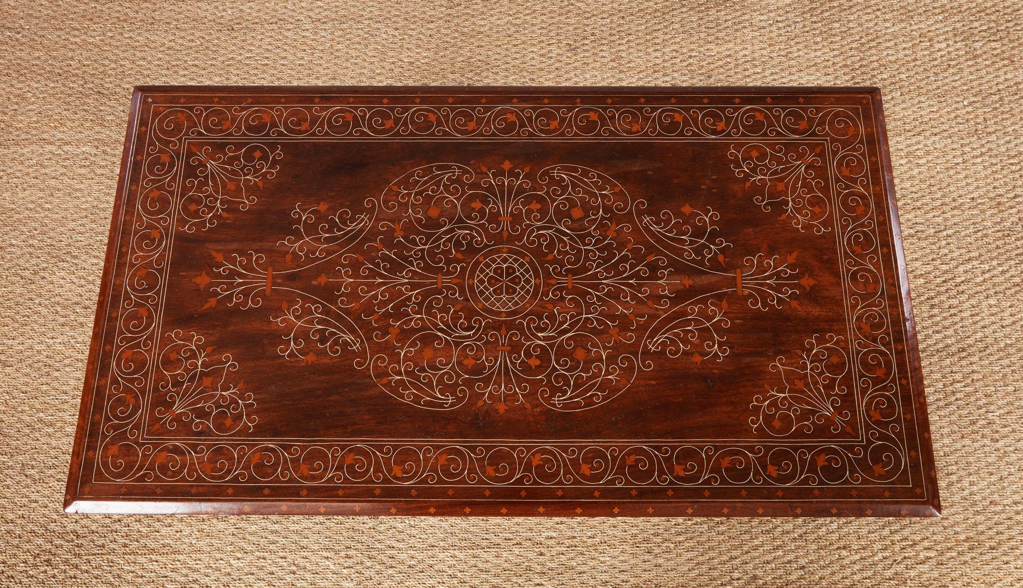 Table à boissons anglo-indienne avec un plateau rectangulaire en bois de santal à bord incliné sur un fin tablier, le tout incrusté de filigrane d'os, et reposant sur de fins pieds tournés en anneau reliés par des brancards croisés et épinglés. Il