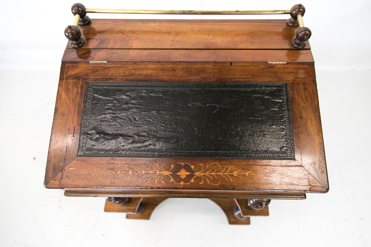 Inlaid English walnut slant top desk with shelves has a slant top that lifts to expose a storage compartment. The top has a brass gallery with wooden baluster supports. The slant front has a black leather blind tool leather insert that is framed