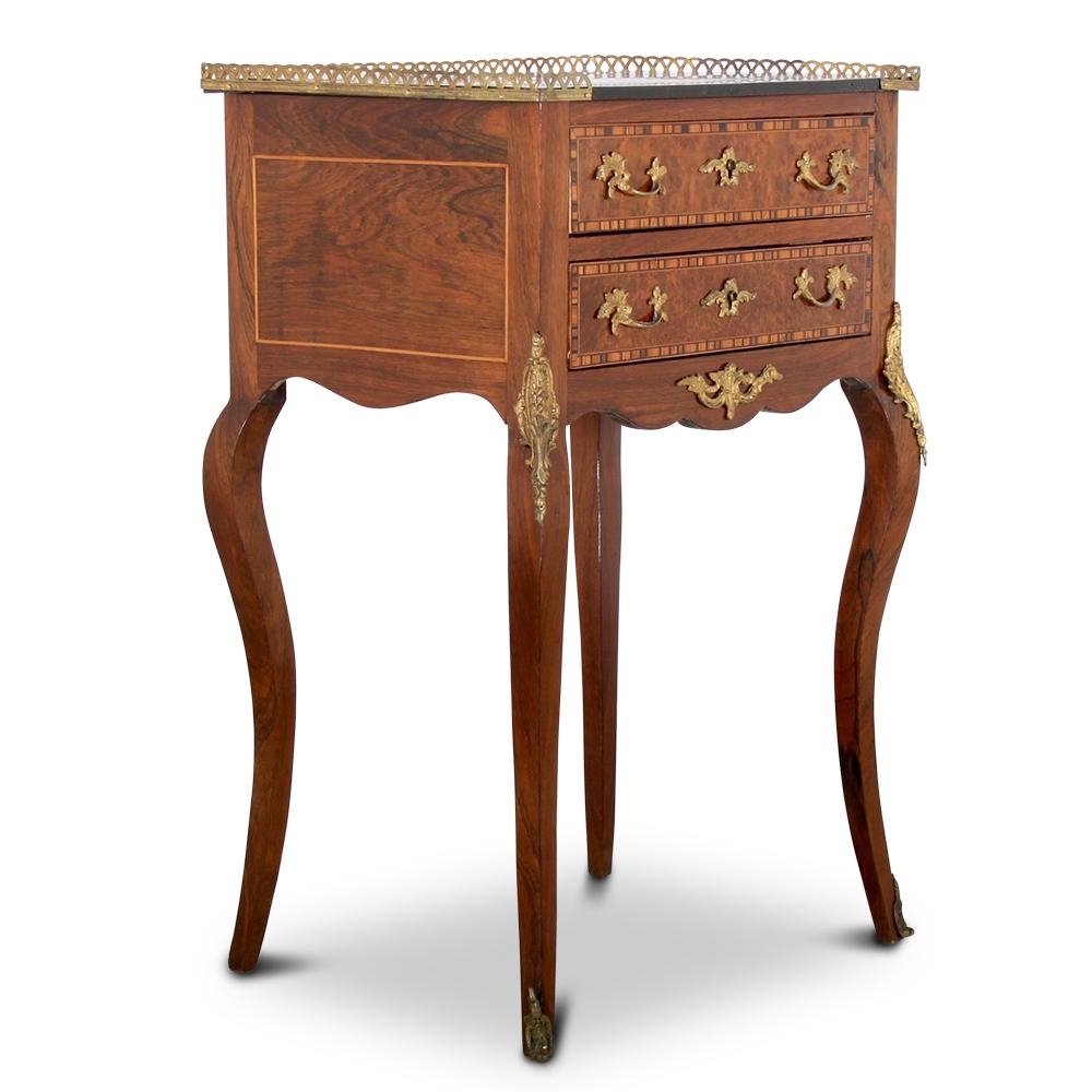 A pretty French Louis XV style two-drawer stand or side table in rosewood inlaid with various other exotic veneers- amboyna, Coromandel, kingwood etc. and further embellished with gilt mounts and a pierced brass gallery.

 