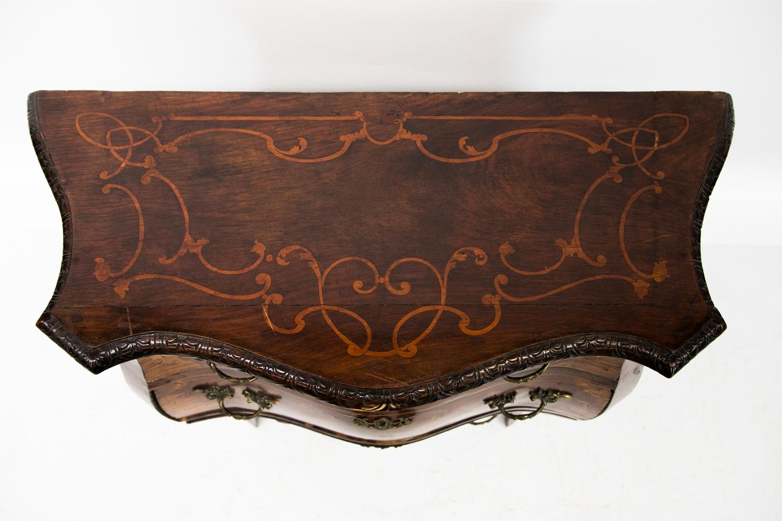 Inlaid French serpentine bombe three-drawer chest is inlaid with boxwood arabesques. It has a floral carved top molding.
  