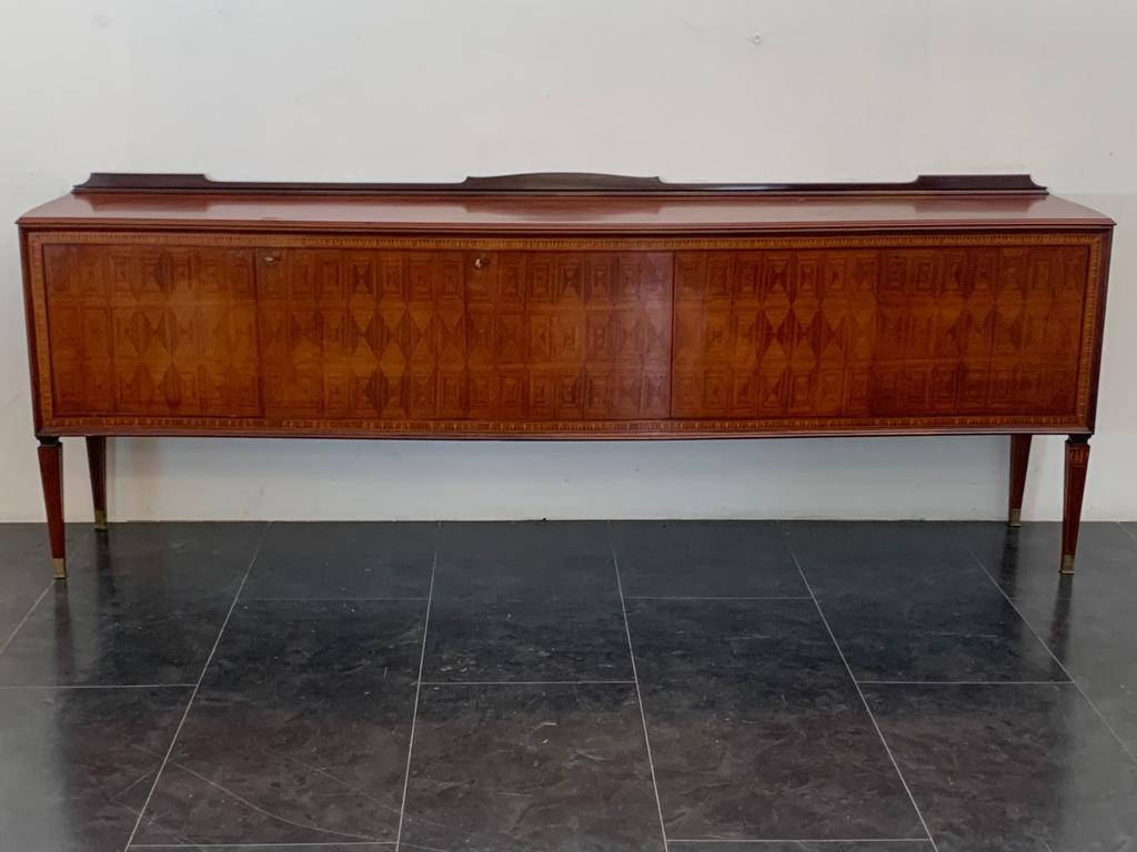 High quality rosewood sideboard moved on front and sides. Front has five lozenge-shaped doors, surrounded by floral inlays. The base and classic spiked leg choked and finely inlaid ends in important brass finials. The top has a splendid diagonal