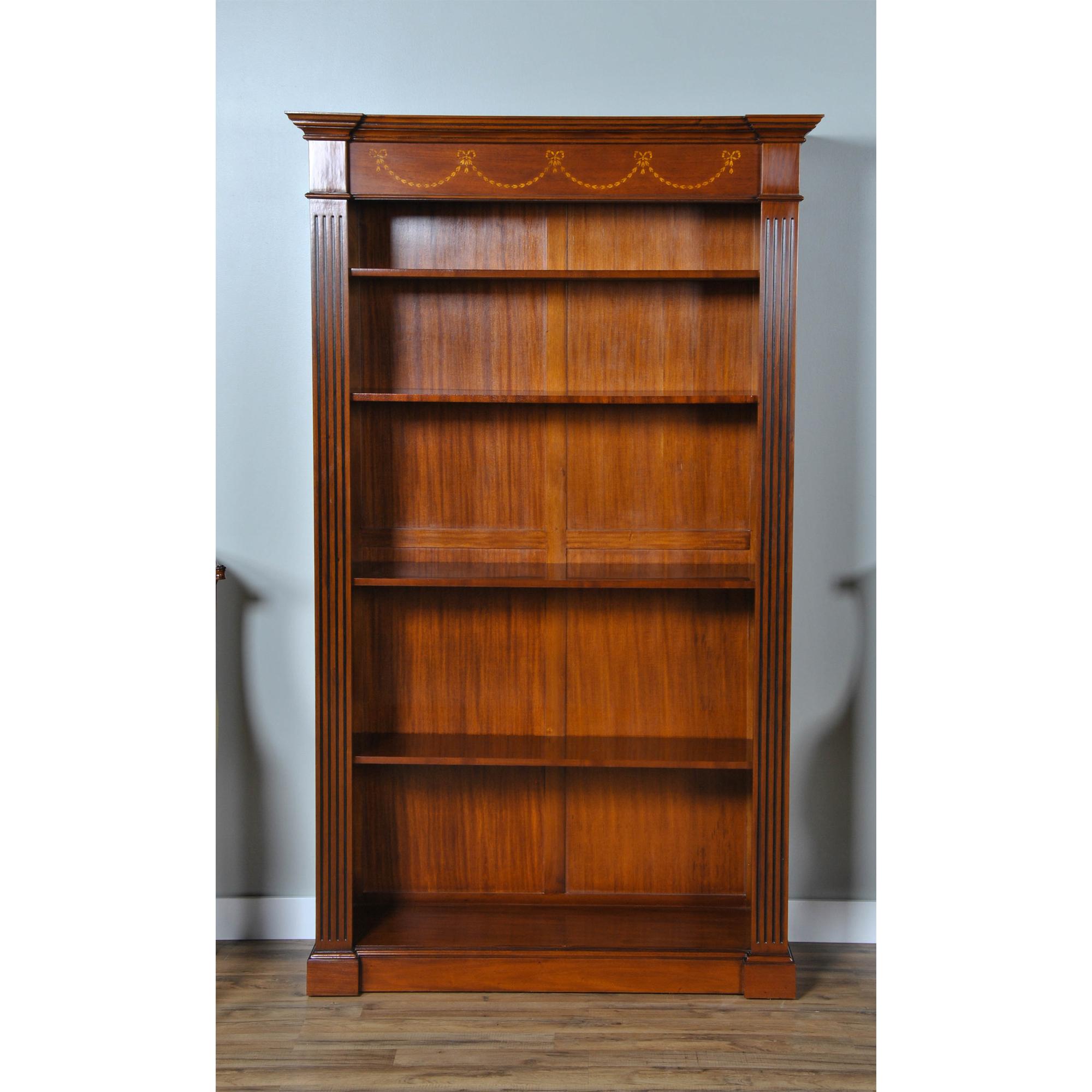 A Superb Quality Inlaid Mahogany Bookcase from Niagara Furniture with bellflower and satinwood inlay decorative details. The top section with a moulded cornice featuring hand cut satinwood inlays in a drape pattern. The open section being flanked by