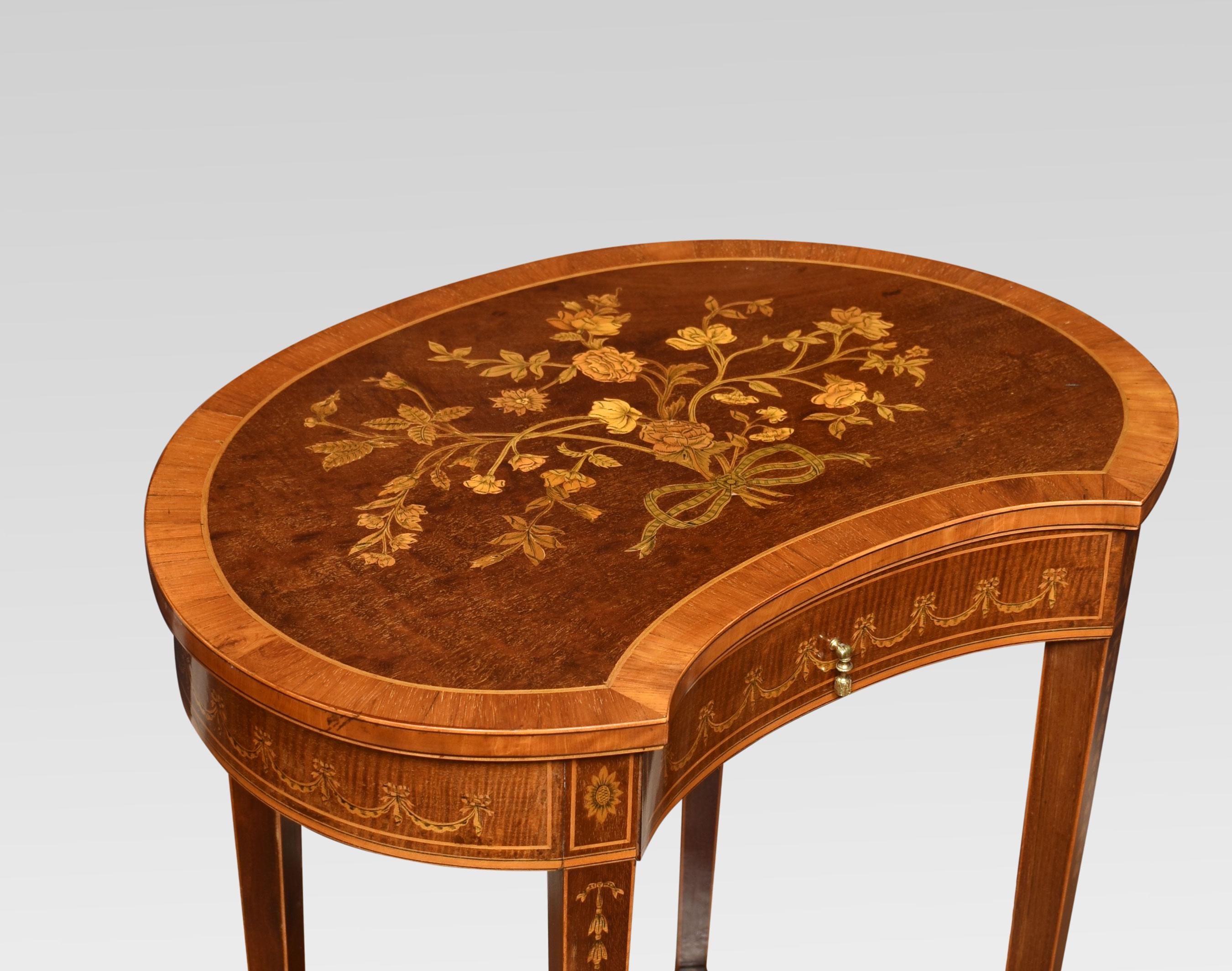 Inlaid mahogany kidney-shaped side table, the plum pudding and banded top decorated with ribbon tied flowers, above a fiddle back mahogany drawer with decorated swag design. Raised up on slender tapering legs with bellflower detail, united by an