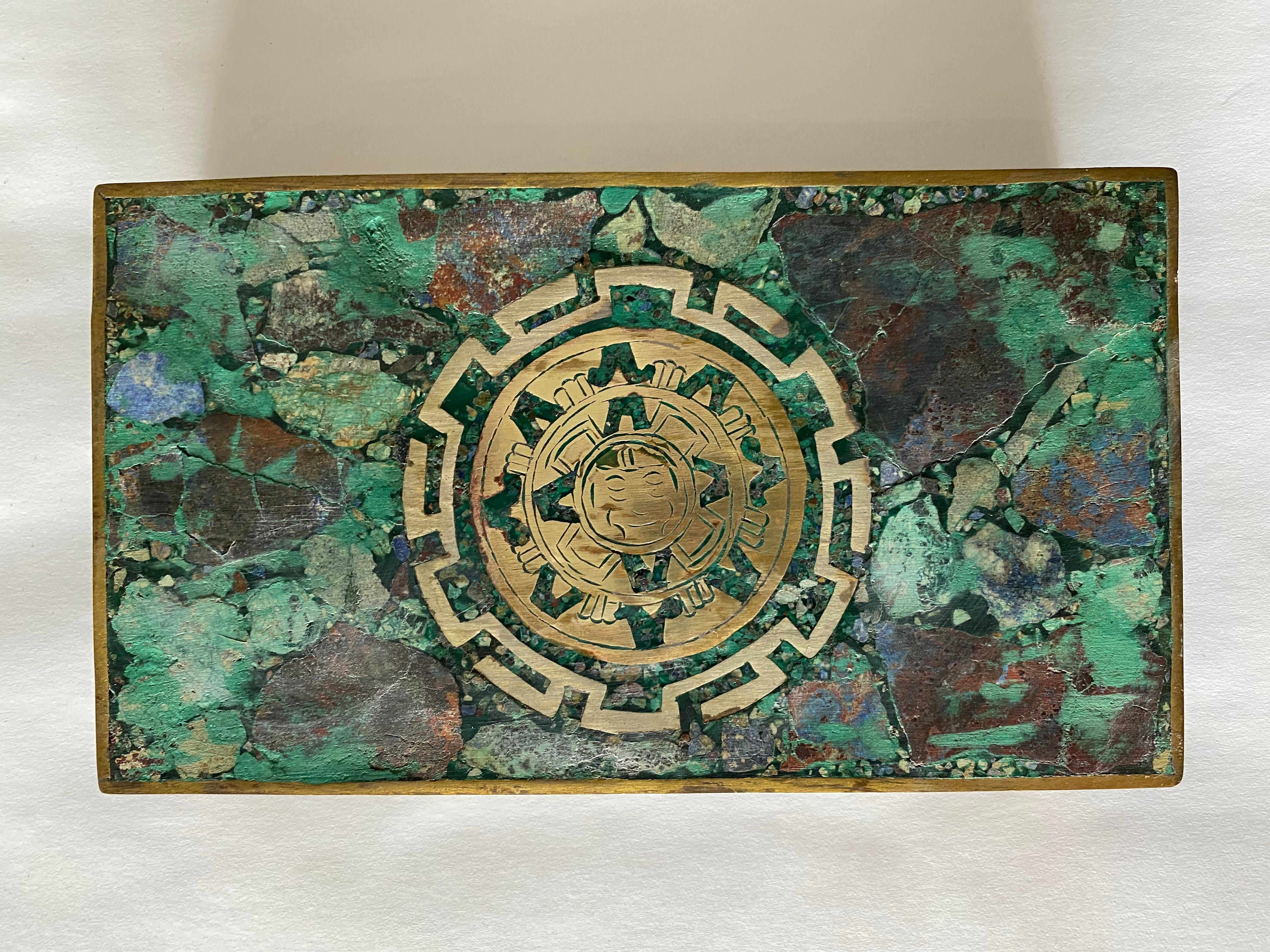 Hinged inlaid malachite and sodalite (looks like lapis lazuli) brass metal box with rosewood interior. The inlaid design is a stylized Aztec calendar wheel. The metalsmiths of Taxco, Mexico were known for producing this type of cigar box in the