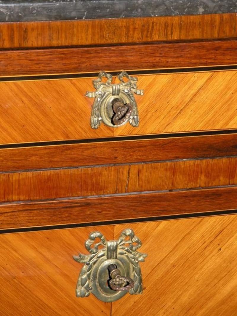 The rectangular white-veined grey marble with outset rounded corners over a conforming case with four drawers, flanked by rounded inlaid continuing to turn the legs with cast feet.