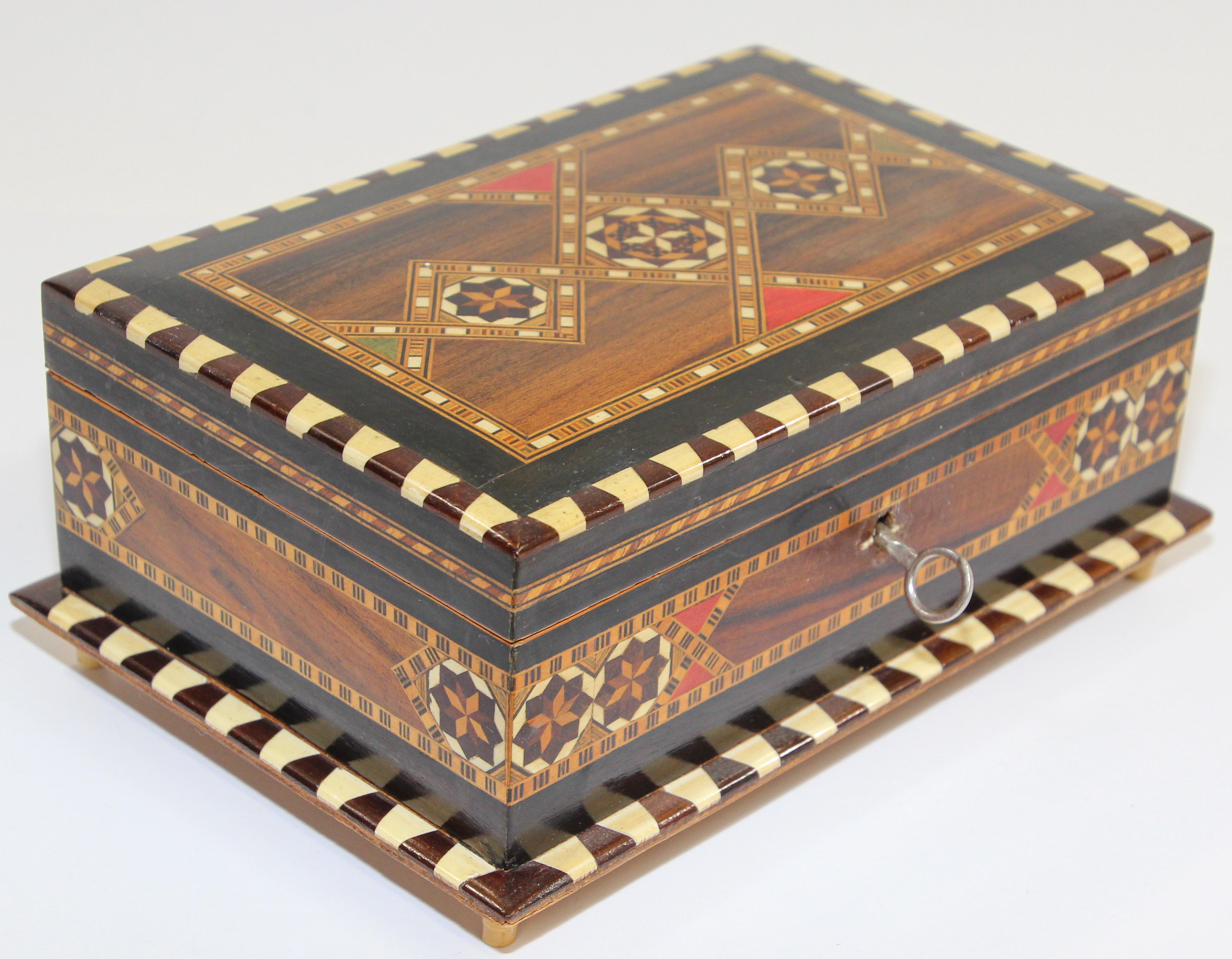 Spanish inlaid Marquetry trinket footed box, cigarette box.
Exquisite handcrafted Middle Eastern mosaic marquetry inlaid walnut wood box.
Handcrafted in Spain in the Moorish Syrian style with original key red velvet lined.
Decorative box