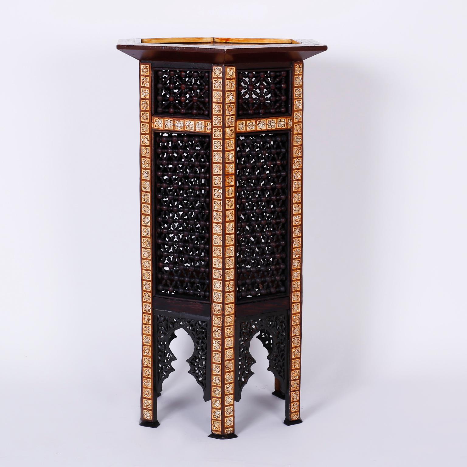 Pedestal crafted with exotic hardwoods such as mahogany, king wood and ebony. The hexagon top features interlocking geometric designs in mother of pearl. The six sided base has stick and ball panels bordered by mother of pearl stars over Moorish