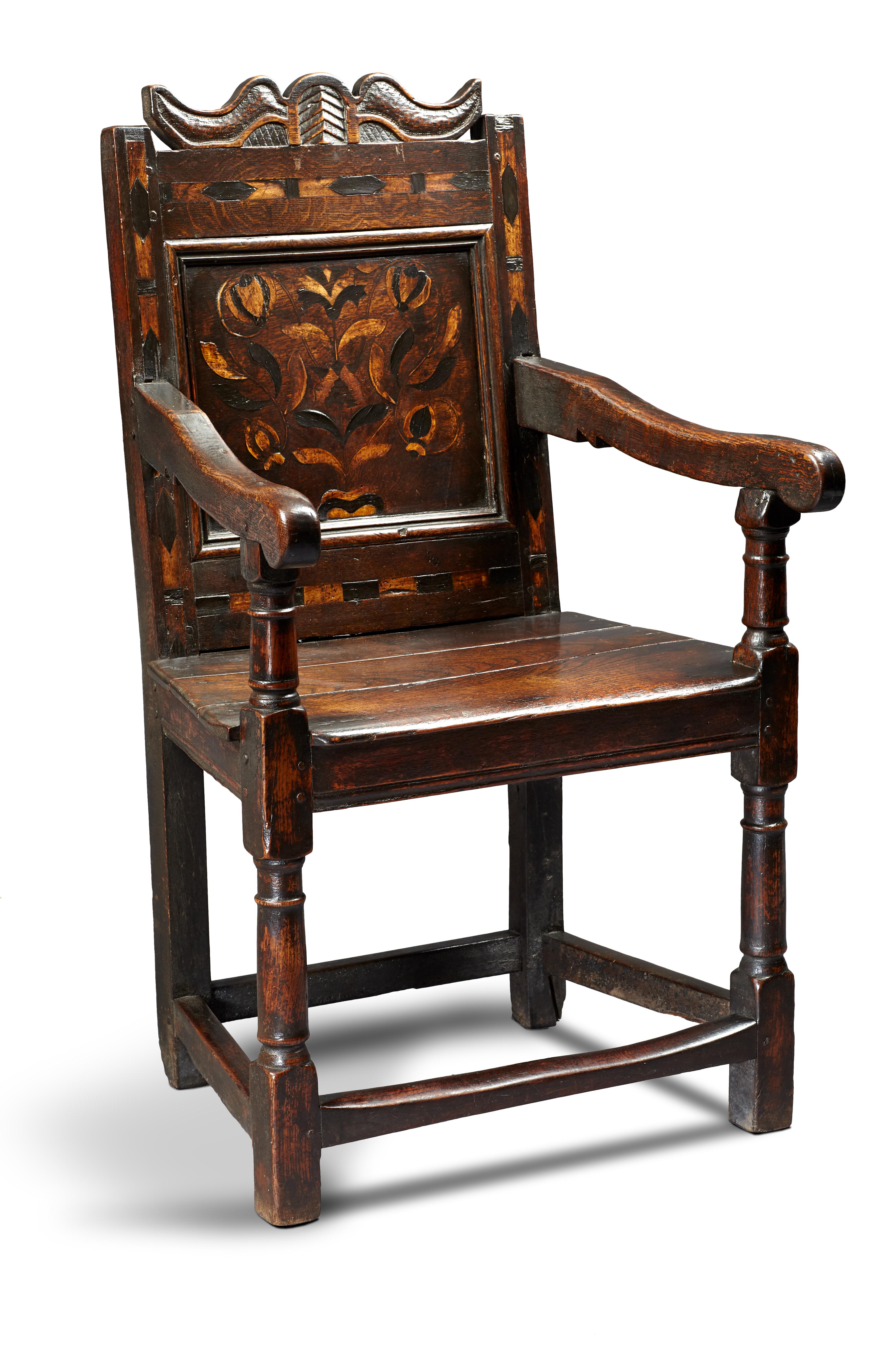 Mid-17th century oak and inlaid armchair, English, Gloucestershire, circa 1640-1650.

The unusual scroll shaped and diaper carved cresting centered upon a palmette above bold chevron inlaid rails with floral inlaid back panel, joined by sloped